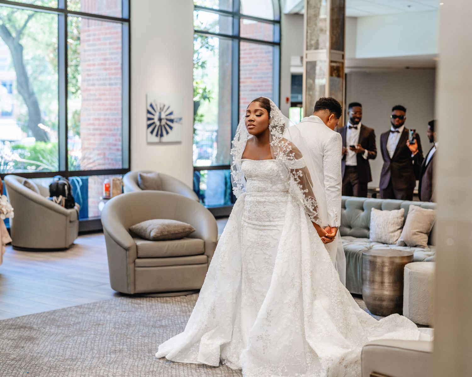 Stunning white wedding gown with lace sleeves and dramatic train in a modern reception venue.
