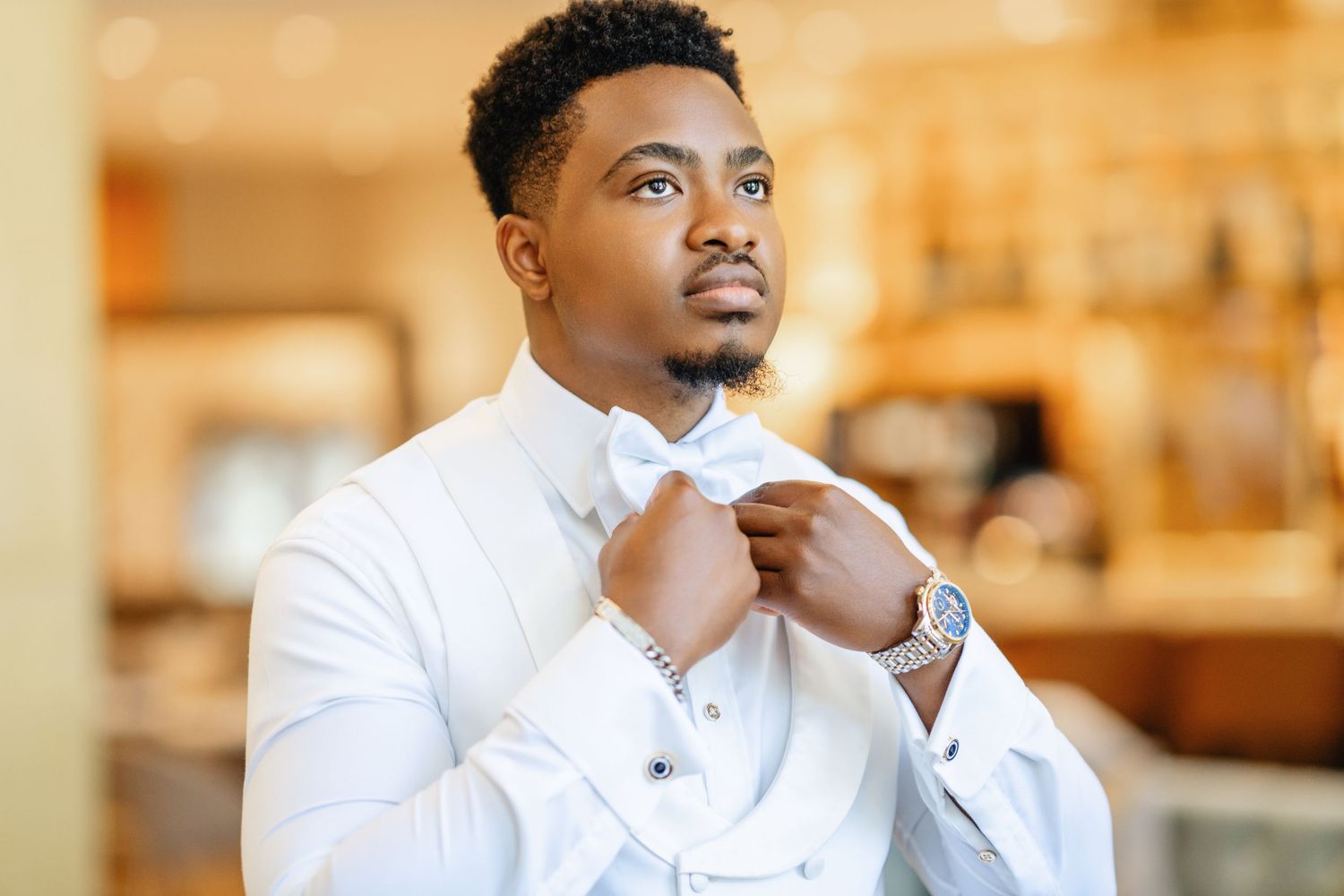 Professional wearing a crisp white button-down shirt looks thoughtfully into the distance in a warm-lit office setting.