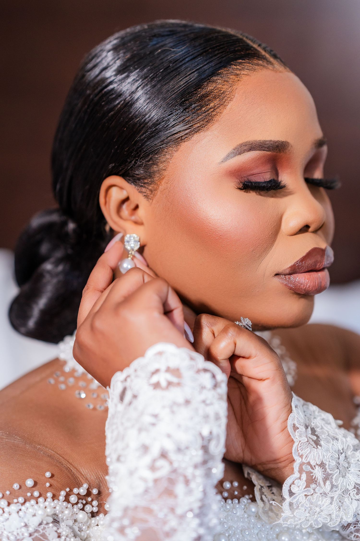 Close-up profile shots of a bride in an elegant white lace wedding dress with diamond earrings and glamorous makeup.