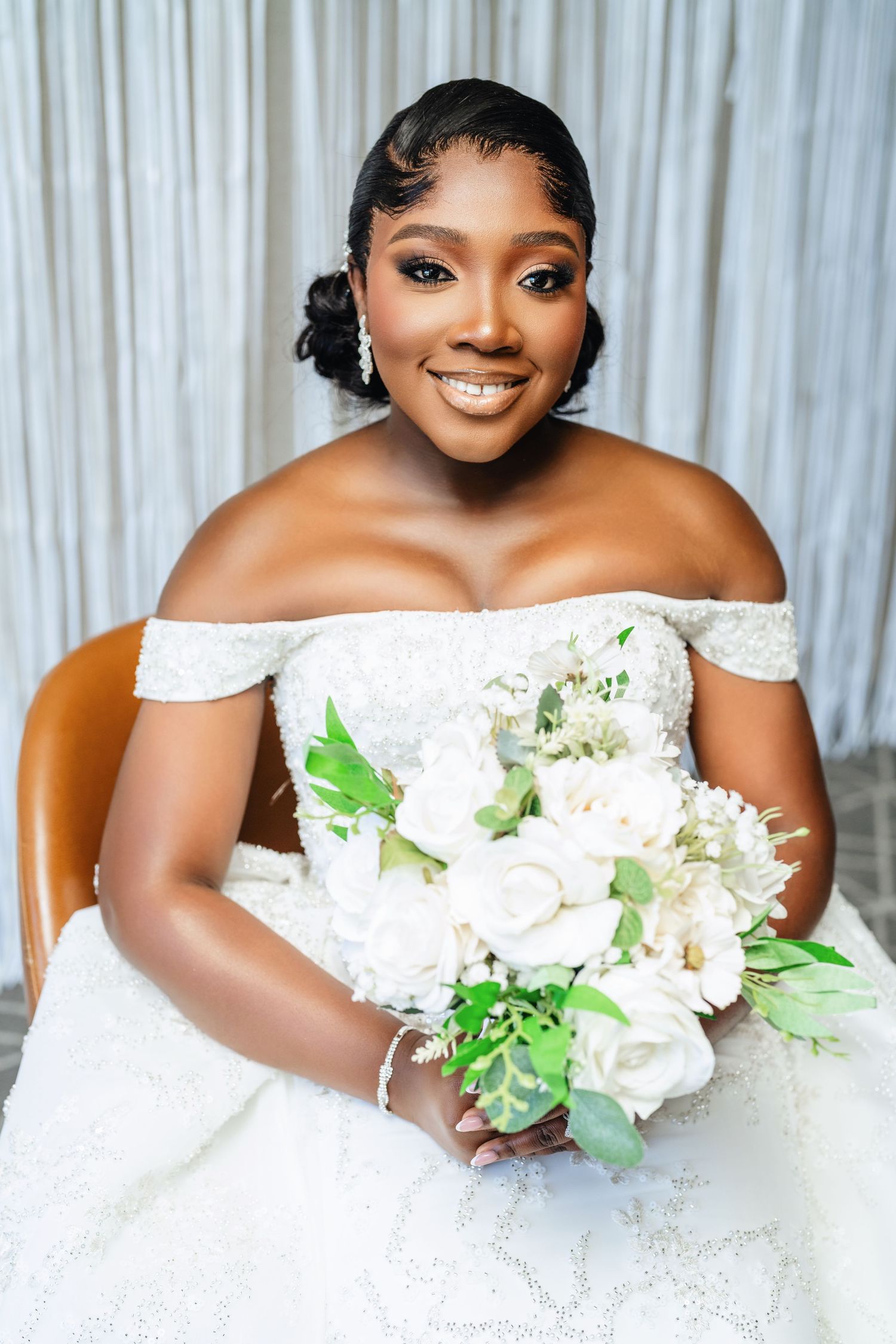 Beautiful white wedding bouquets with fresh flowers and greenery against a light backdrop.