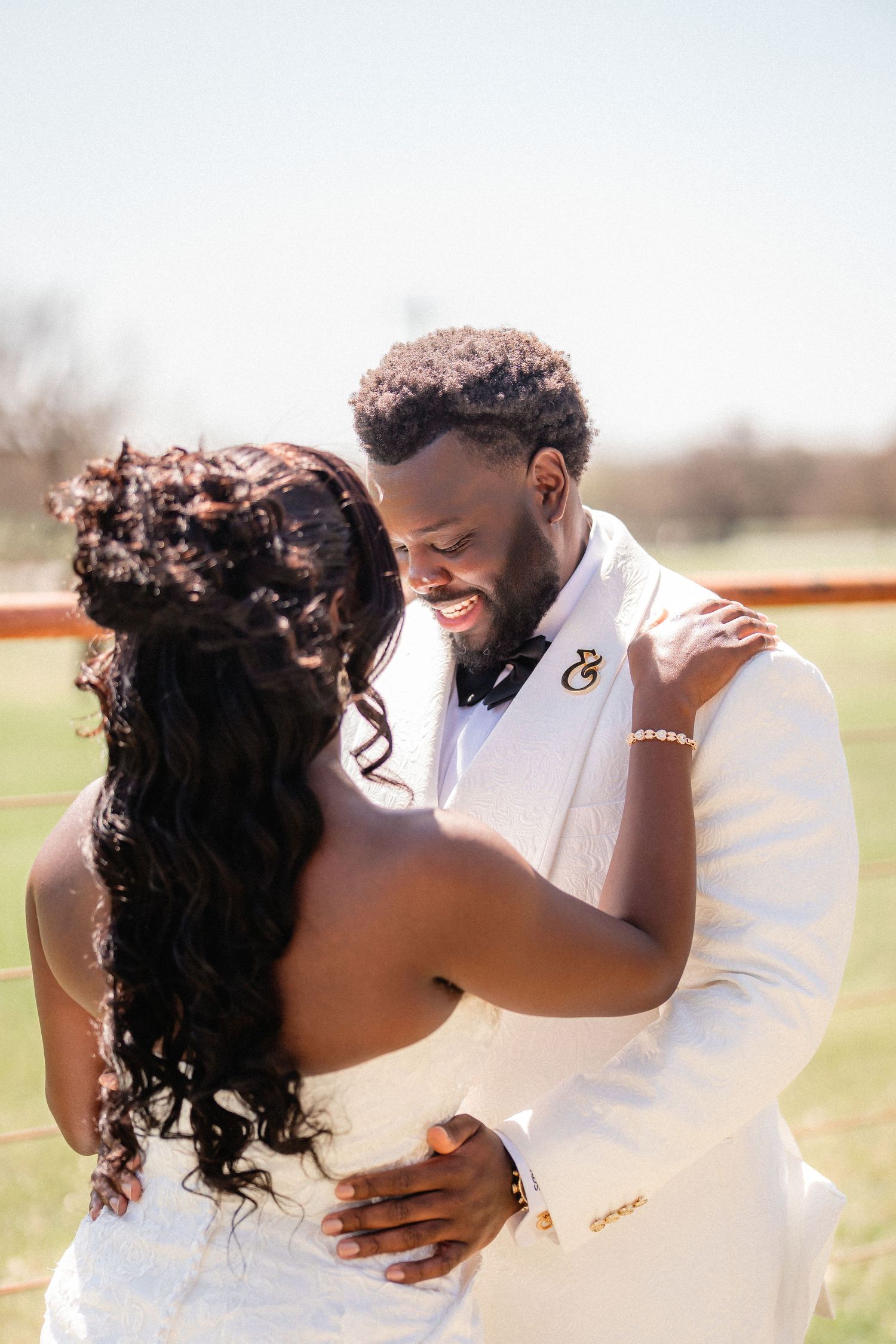 Romantic outdoor wedding photo shoot showing intimate moments between newlyweds in a sunlit field.