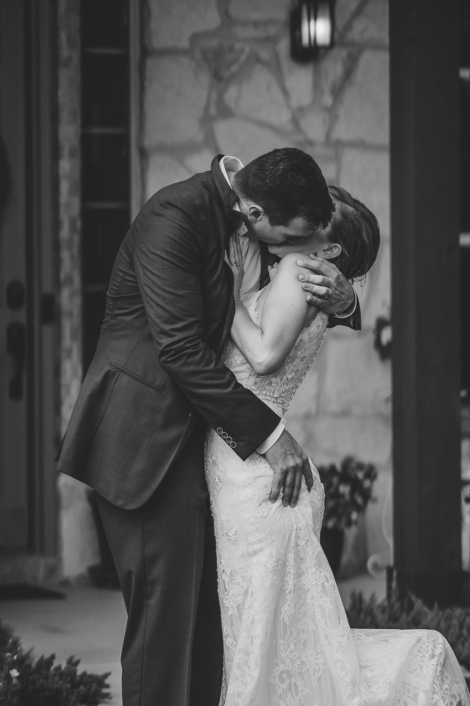 A romantic black and white wedding photo captures a couple sharing an intimate kiss on their special day.