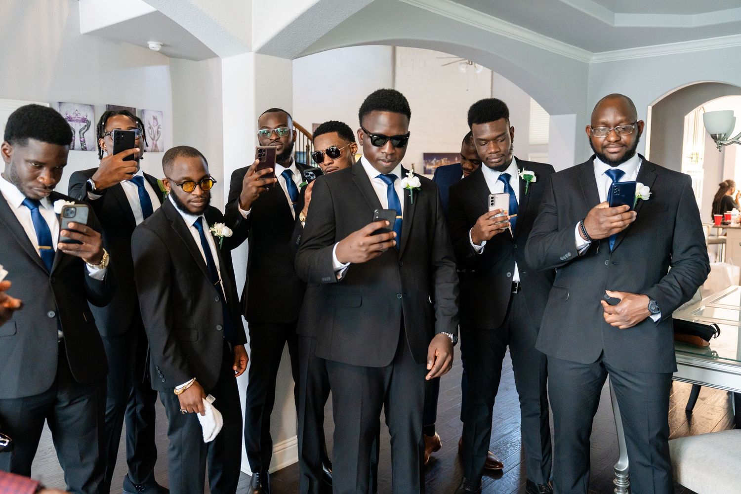 Groomsmen in dark suits lined up for a wedding photo.
