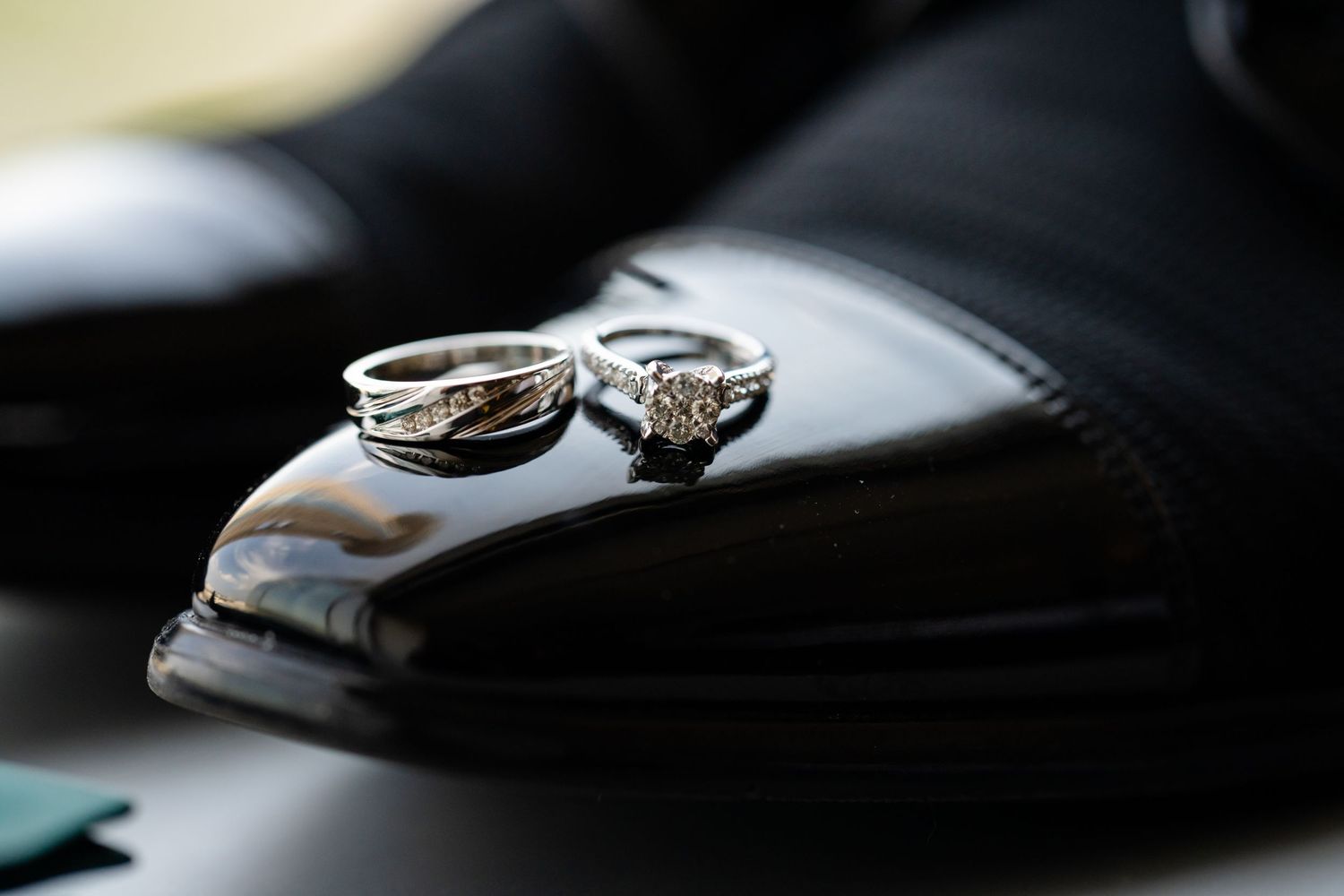 Wedding rings resting on shiny black leather surface with soft focus.