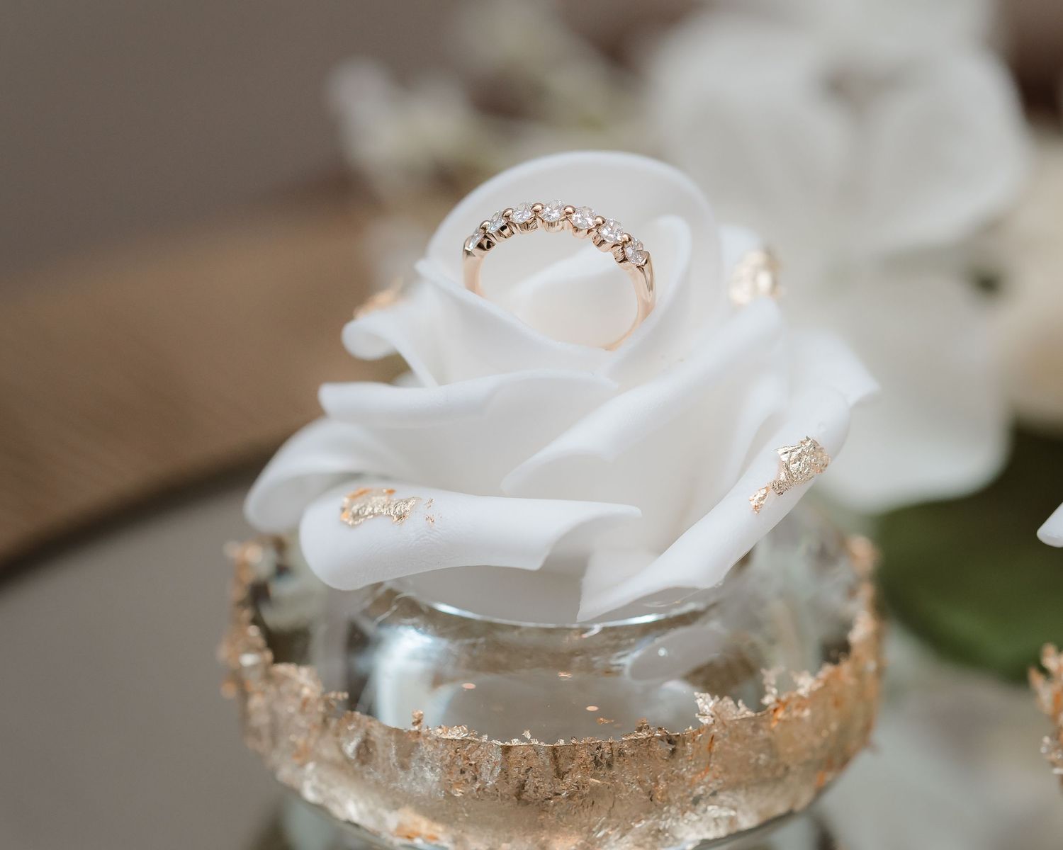 White roses with gold-dipped edges arranged in a romantic display for elegant wedding decor.