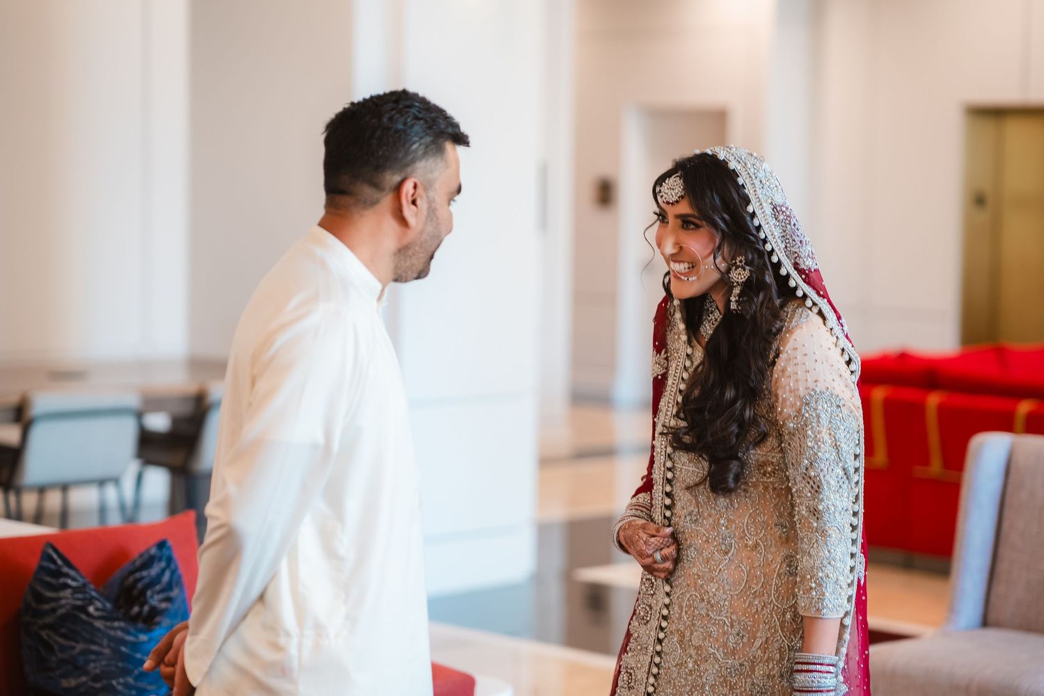 A couple shares an intimate moment during their first dance at an elegant indoor wedding reception.