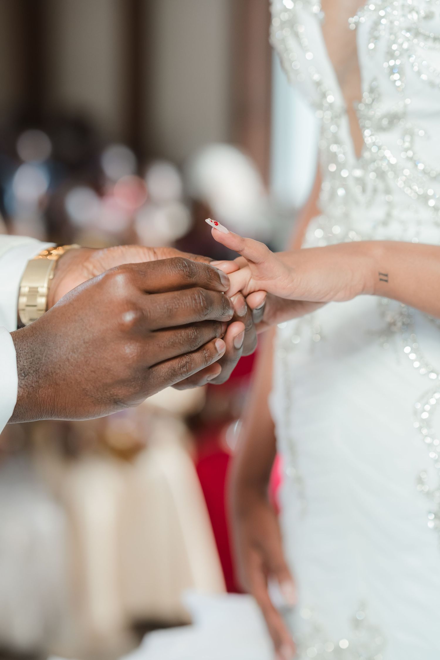 Close-up of hands exchanging wedding rings during a ceremony.