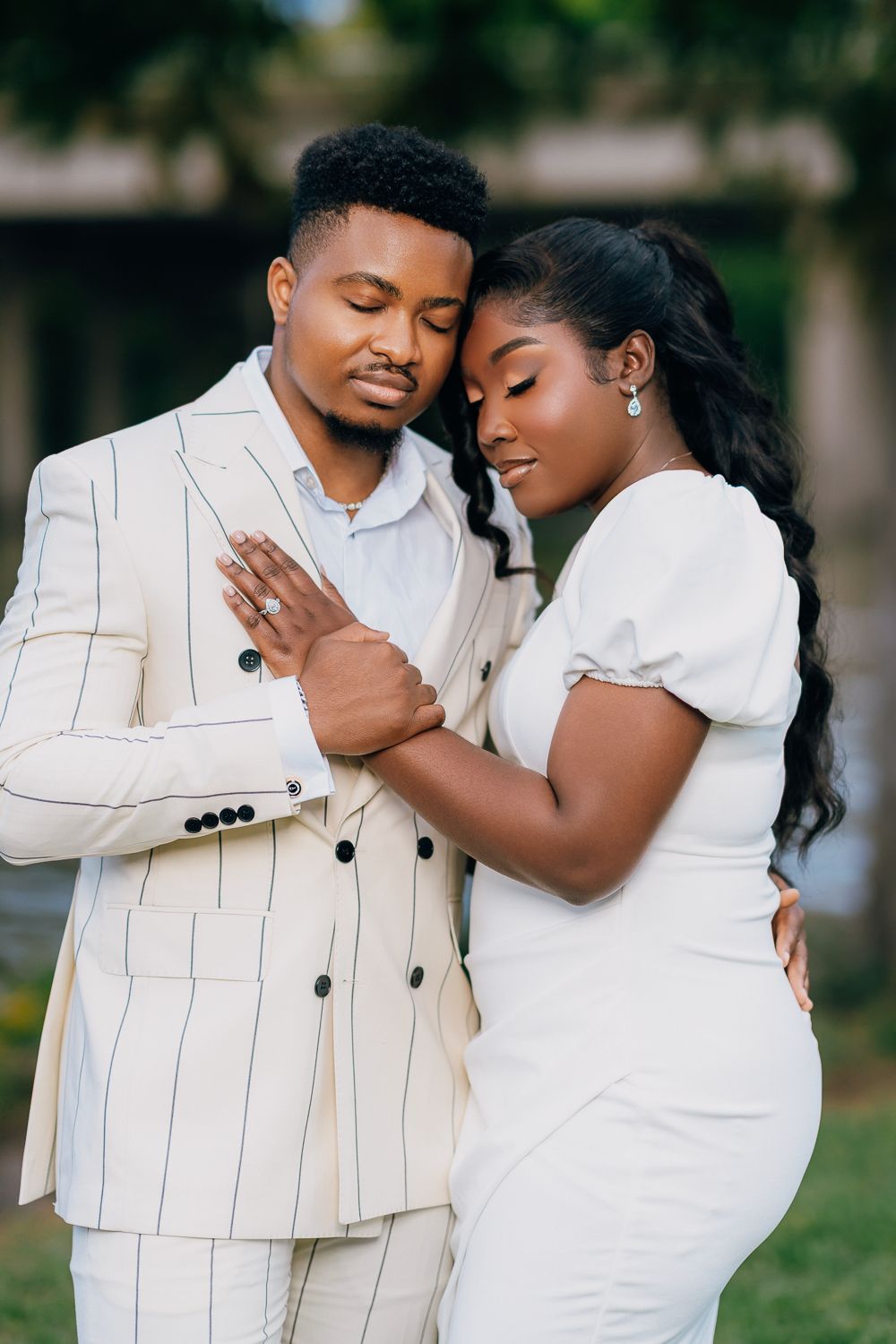 A romantic couple in white outfits share tender moments together in a series of outdoor portrait photos.