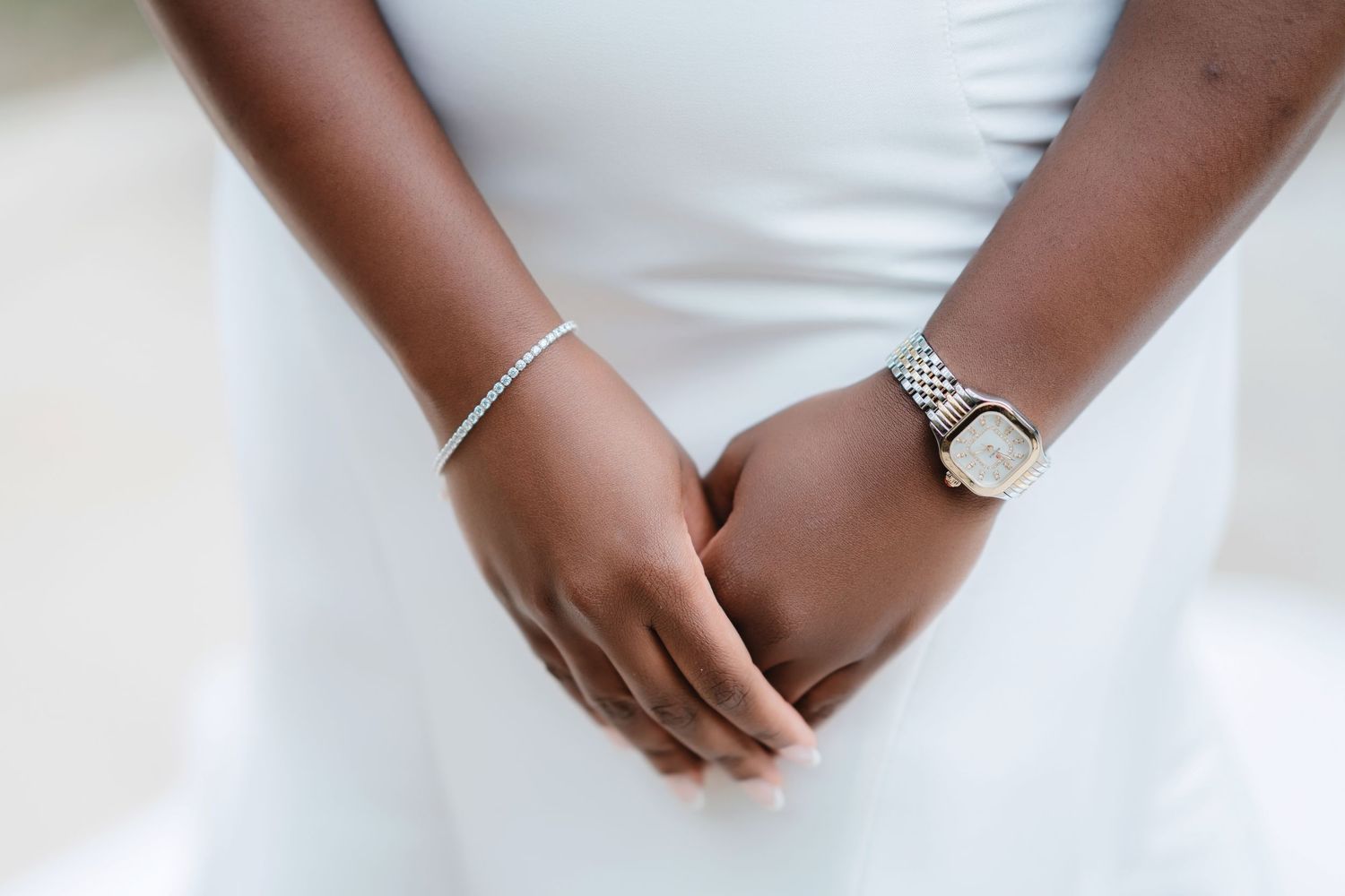 Close-up details of a bride's white wedding dress and accessories during preparation.