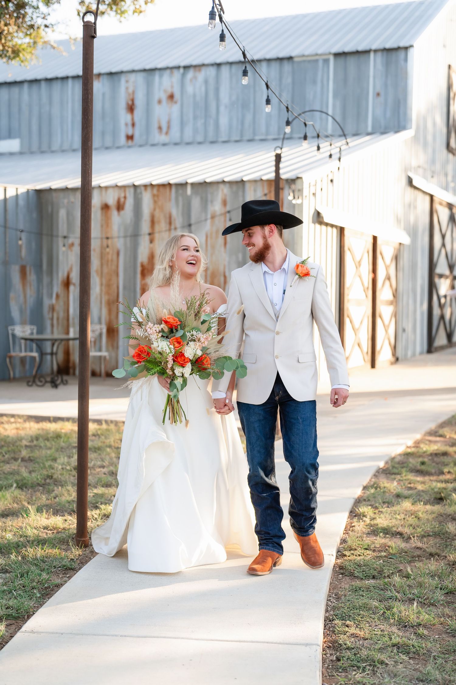 Rustic outdoor wedding photos with couple in white attire against barn backdrop.
