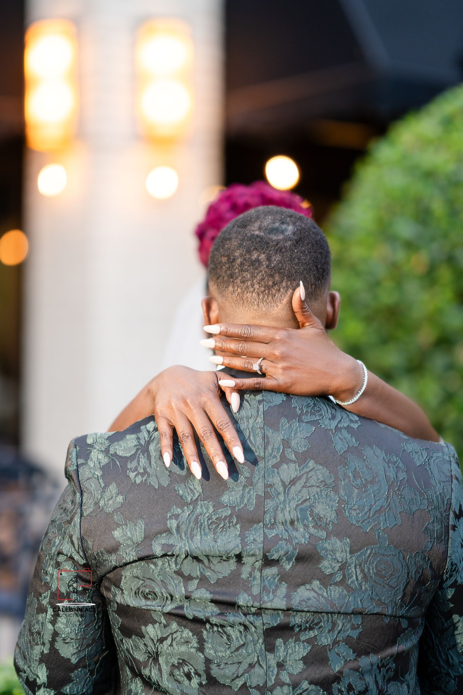 Close-up shots of an elegant wedding couple embracing, focusing on the detailed jacket pattern.