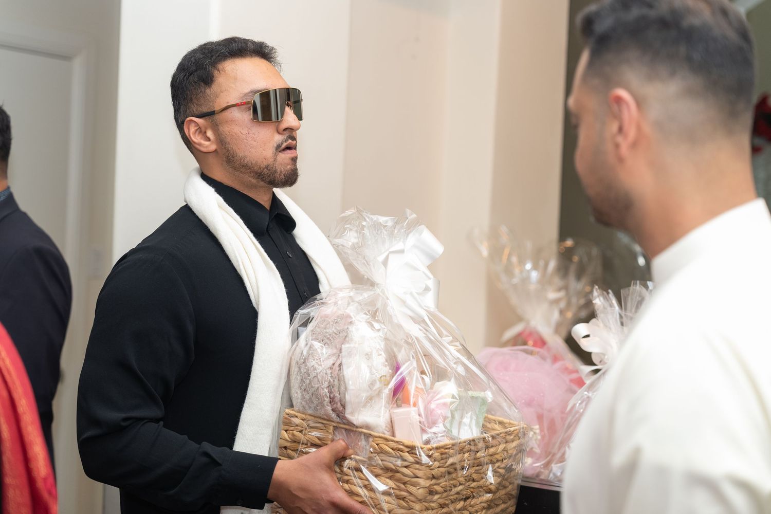Wedding celebration scene with guests in formal attire exchanging gifts.