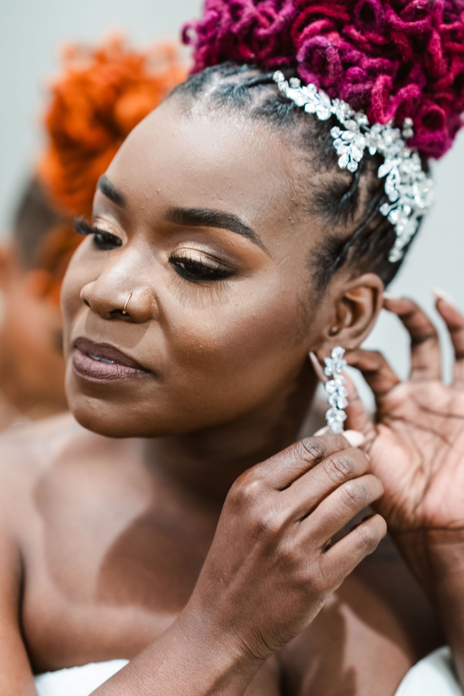Close-up bridal portrait showcasing magenta updo hairstyle and crystal hair accessories.