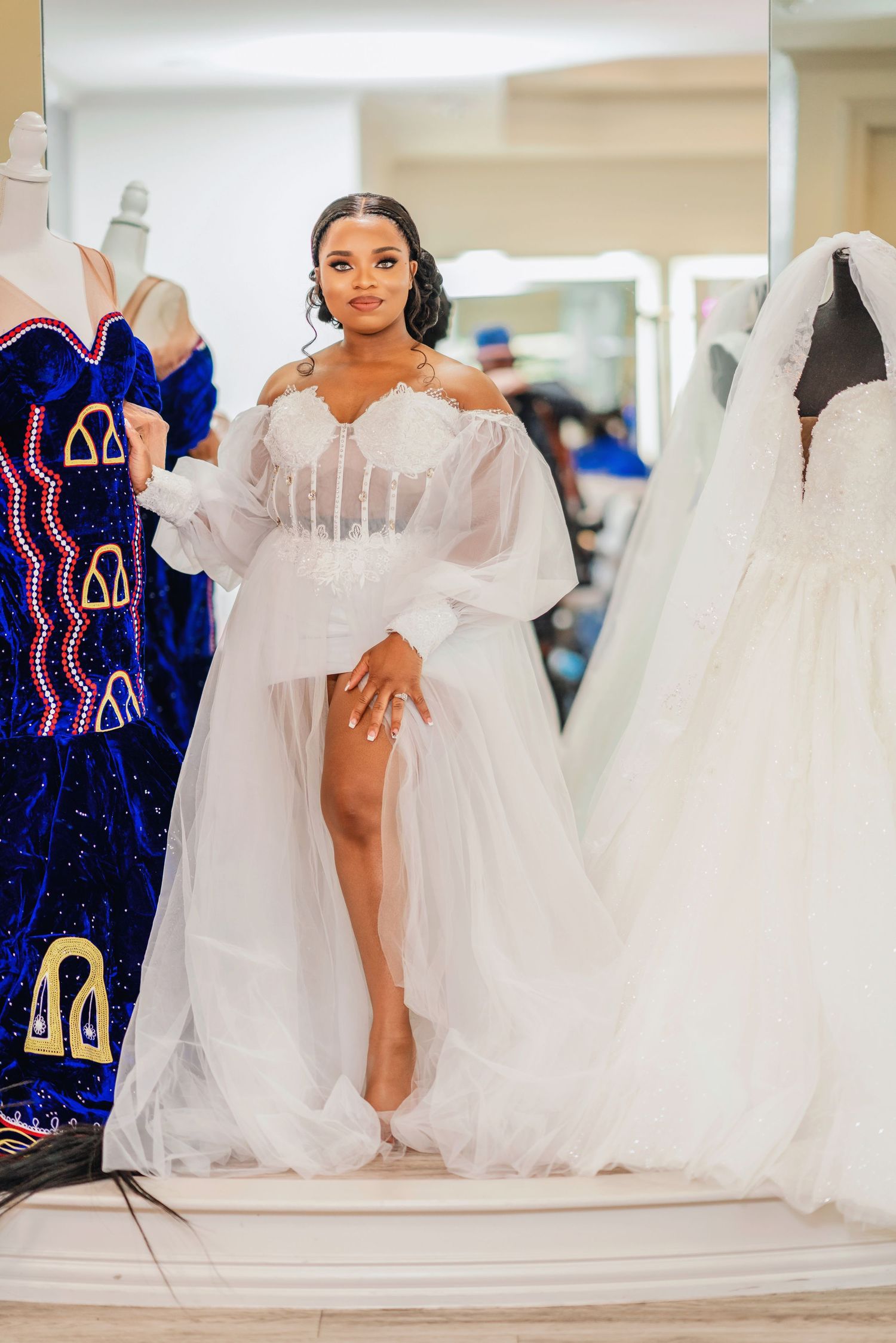An elegant white wedding gown display with royal blue bridesmaid dresses in the background.