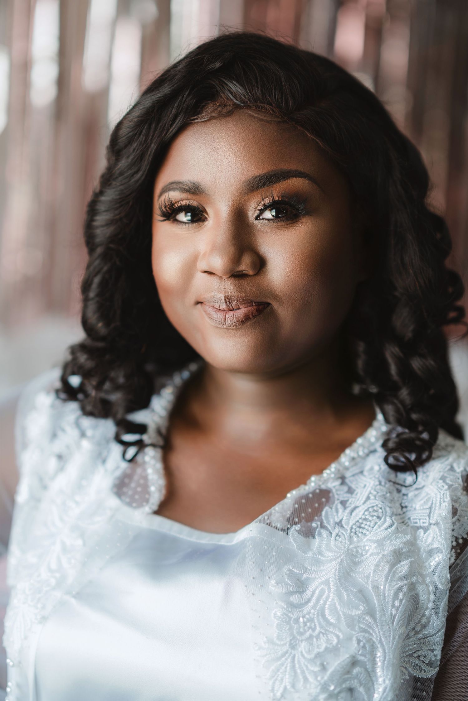 Close up bridal portrait showing intricate lace details of a white wedding gown.