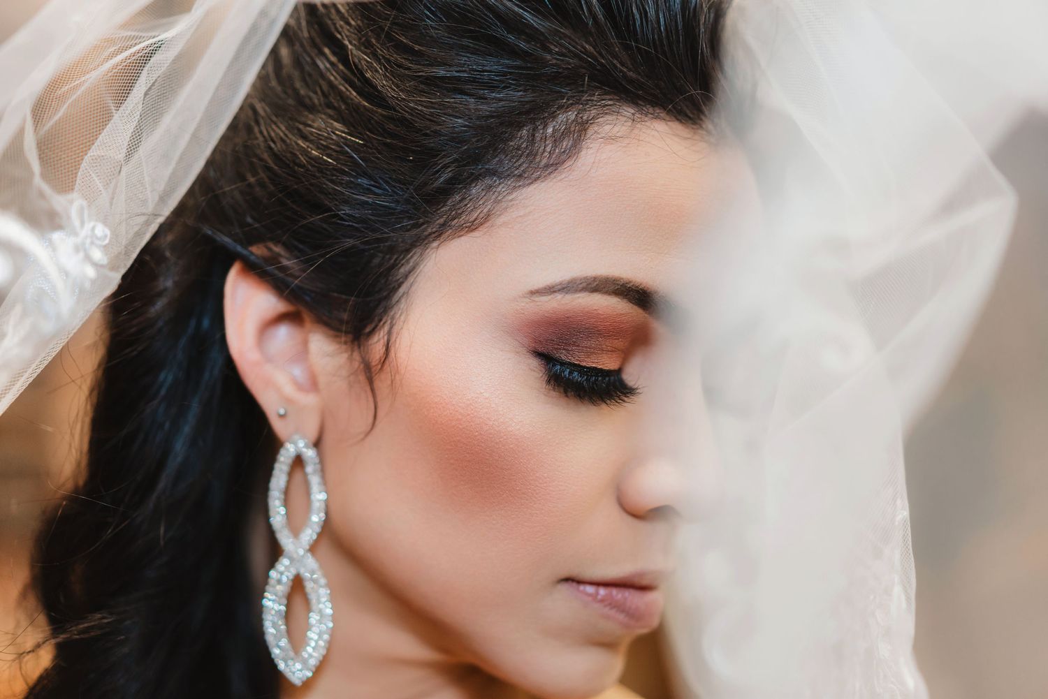 Close-up beauty shot showing glamorous bridal makeup with shimmering eyeshadow and long lashes.
