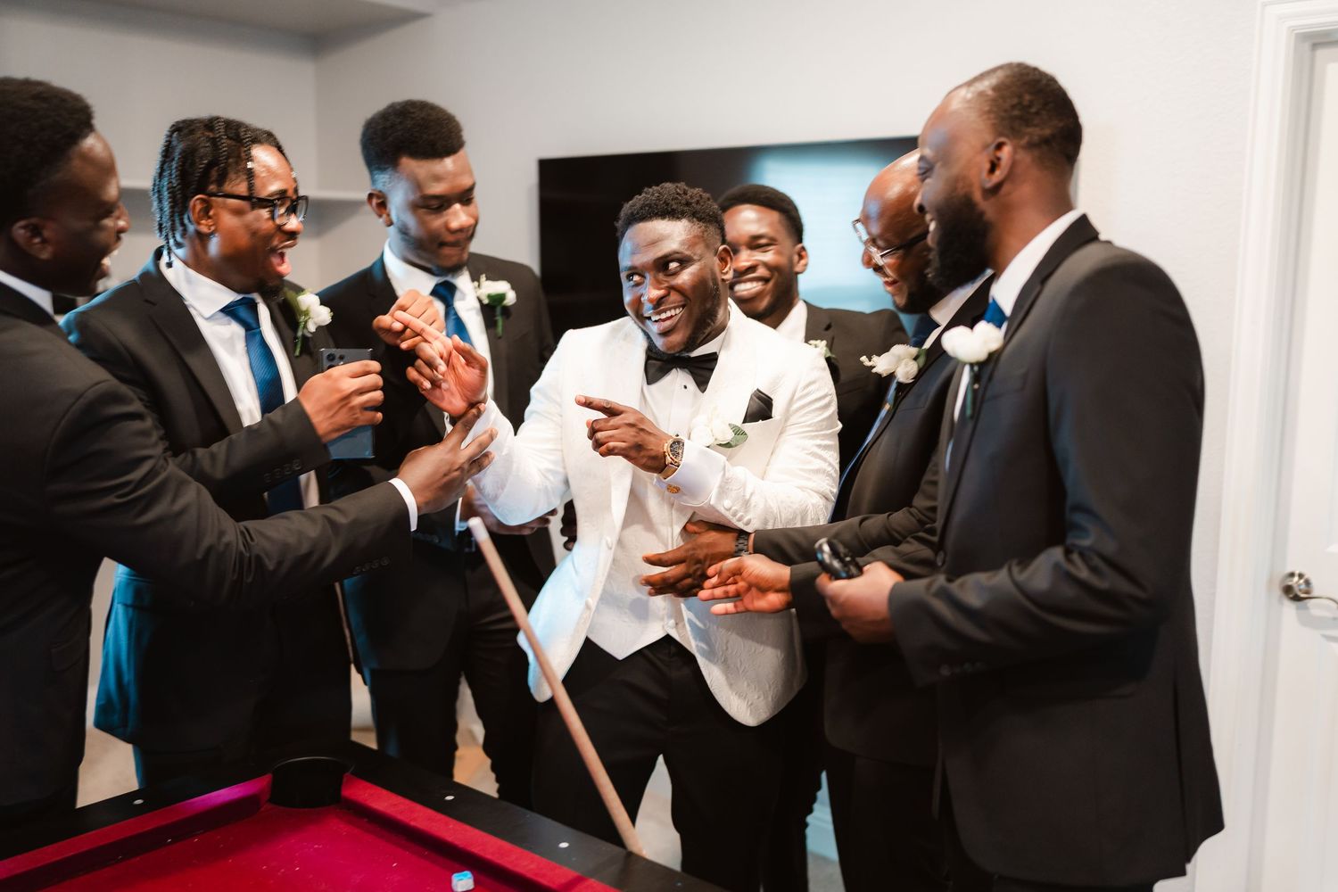 Group wearing formal attire gathered in celebration at indoor event.