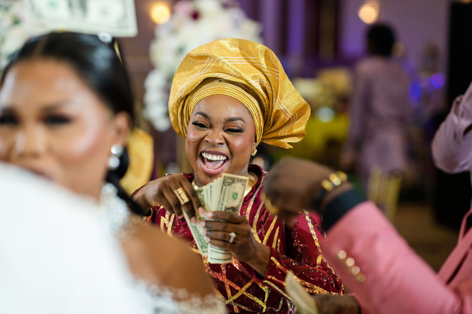 Wedding guests in colorful traditional attire celebrating joyfully at a reception.