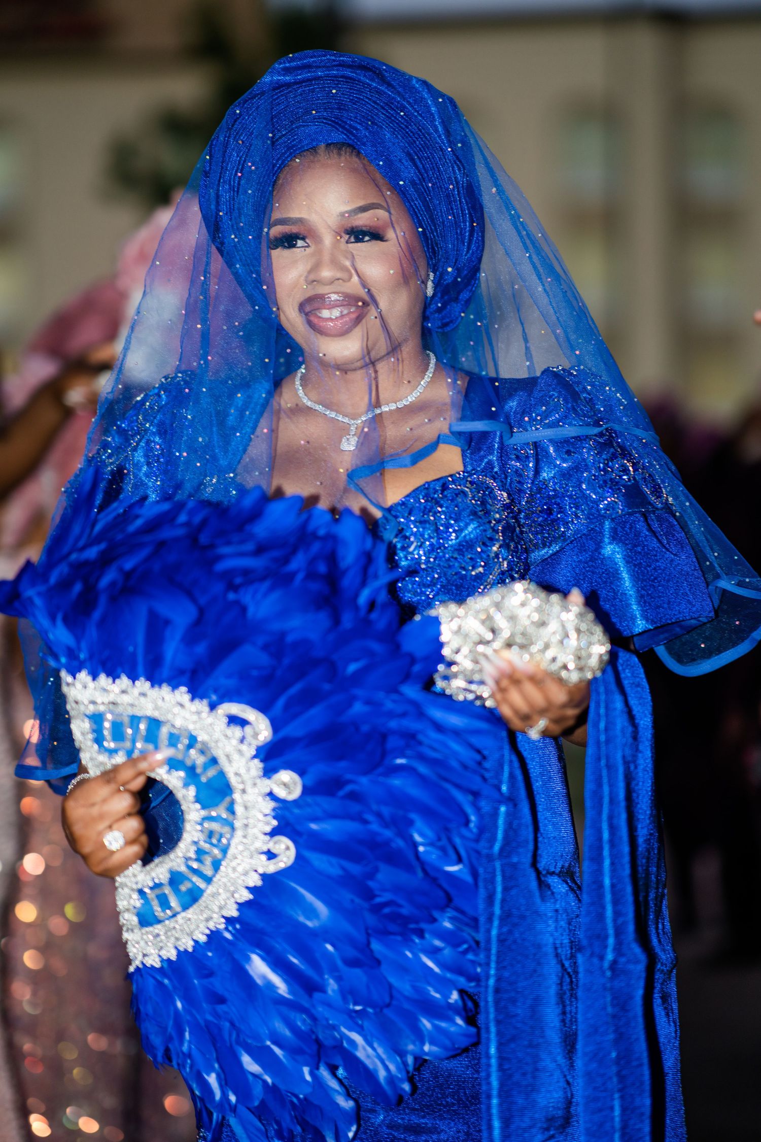Wedding celebration featuring vibrant royal blue traditional attire with intricate white lace details.