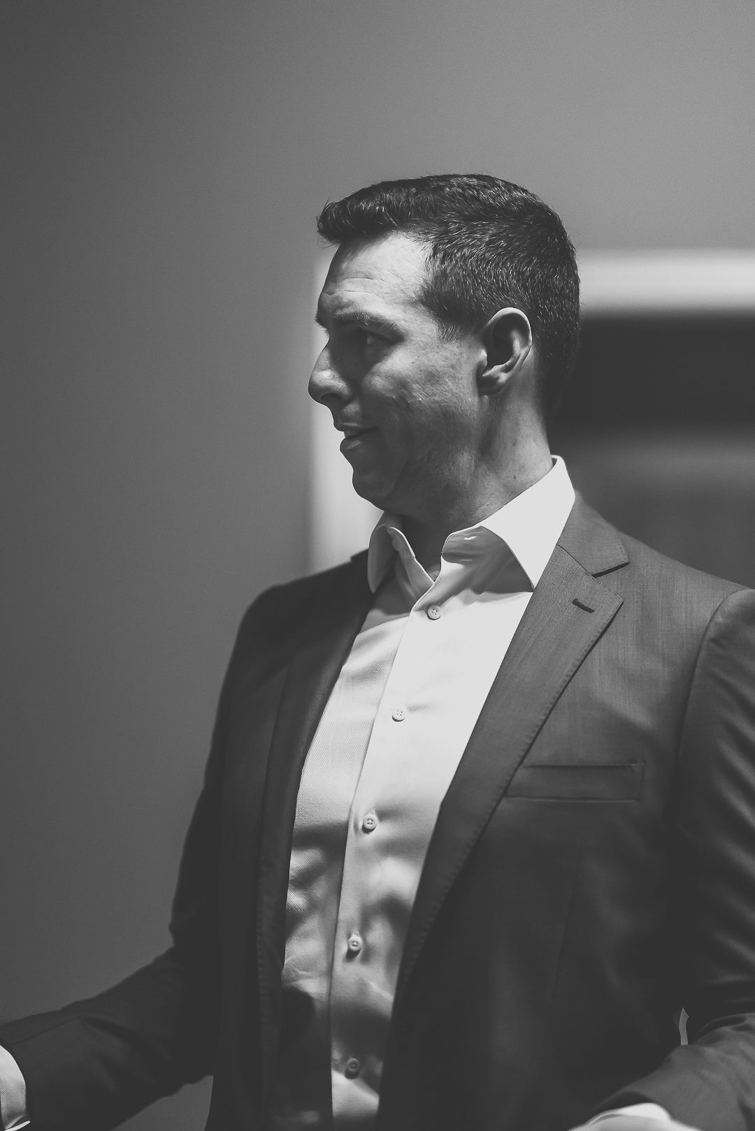 Professional black and white profile portraits of a man in a suit with dramatic lighting and shadows.