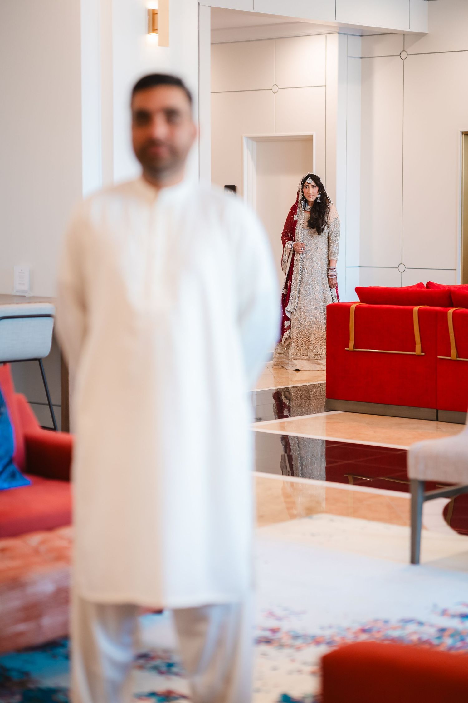 Modern interior room with red couches and white walls set up for a wedding ceremony.