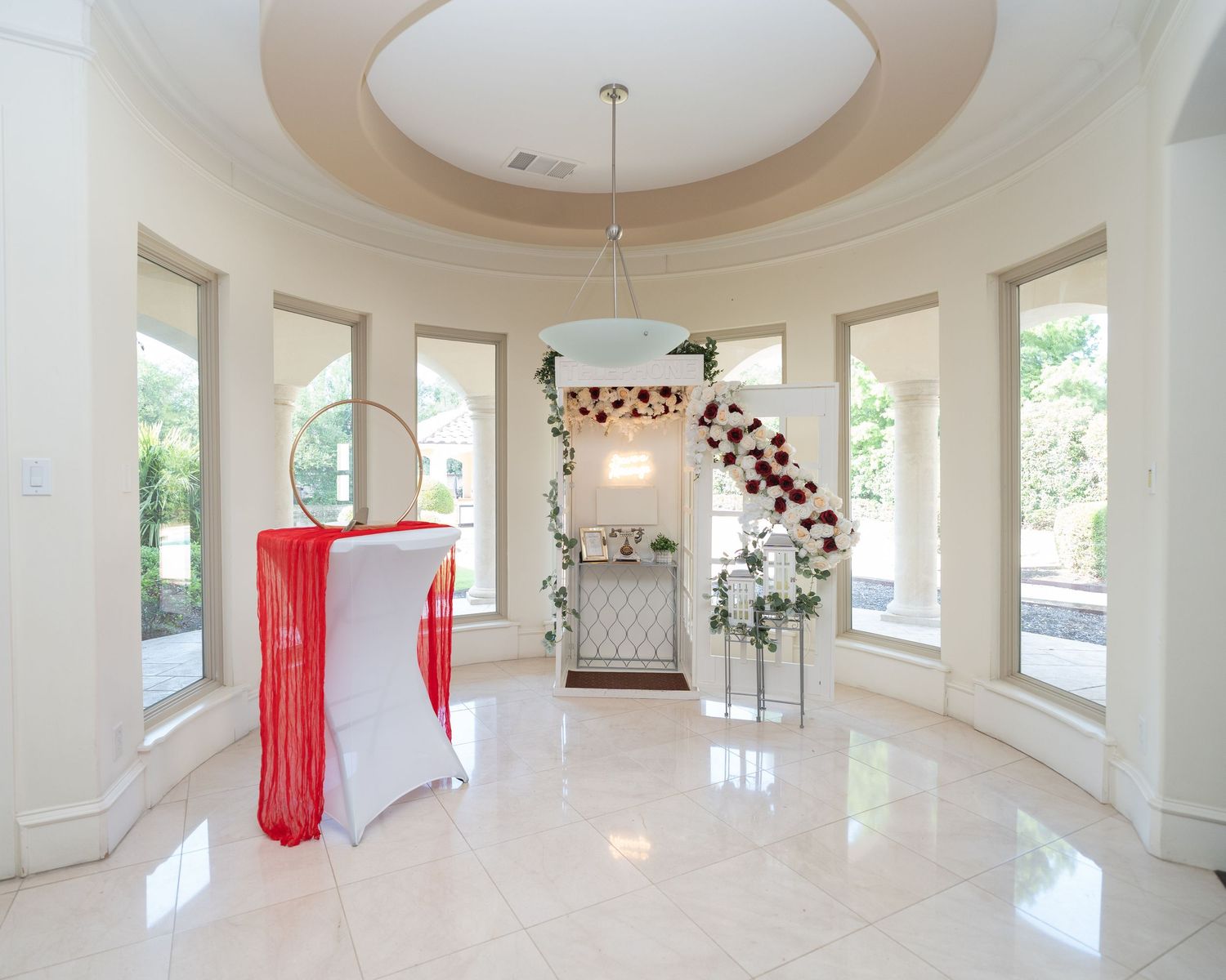Elegant circular room with marble floors and floral arch decoration.