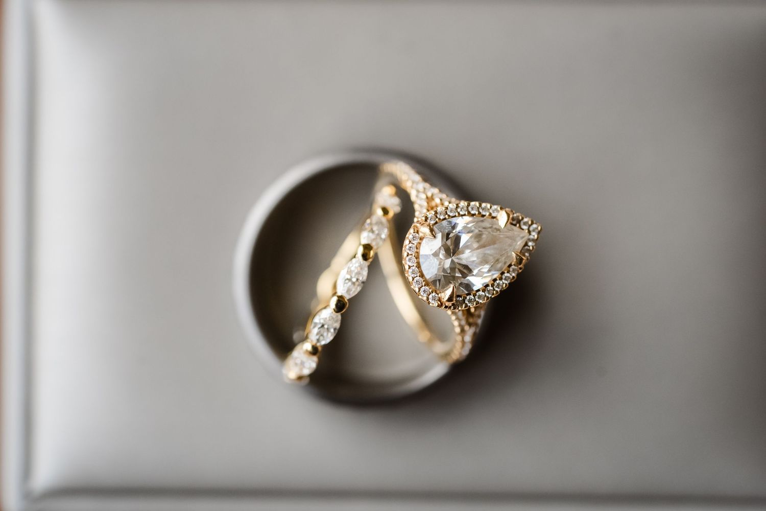 A collection of silver and diamond engagement rings displayed on a white surface in a row.