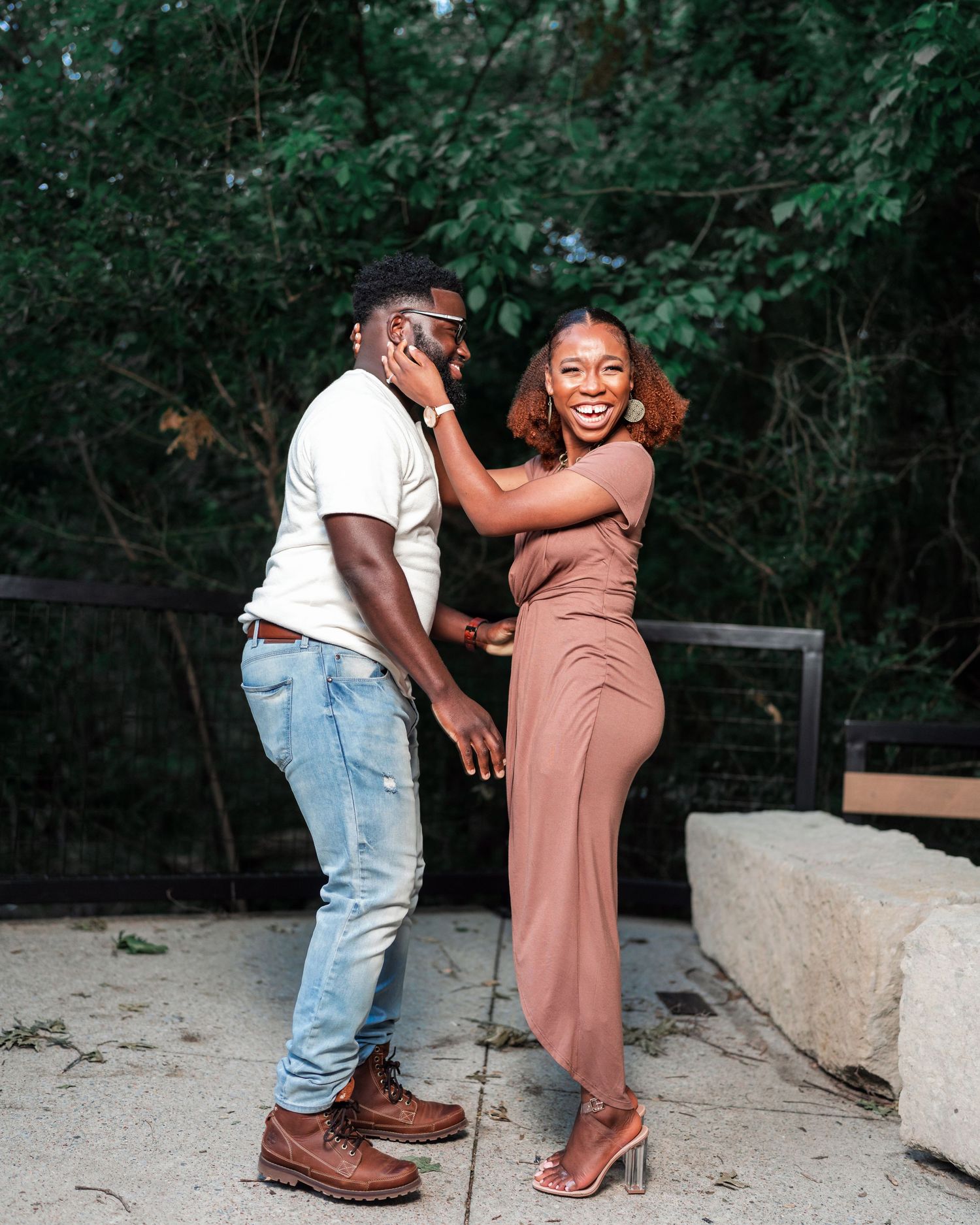 A couple laughs and dances together during an outdoor photoshoot.