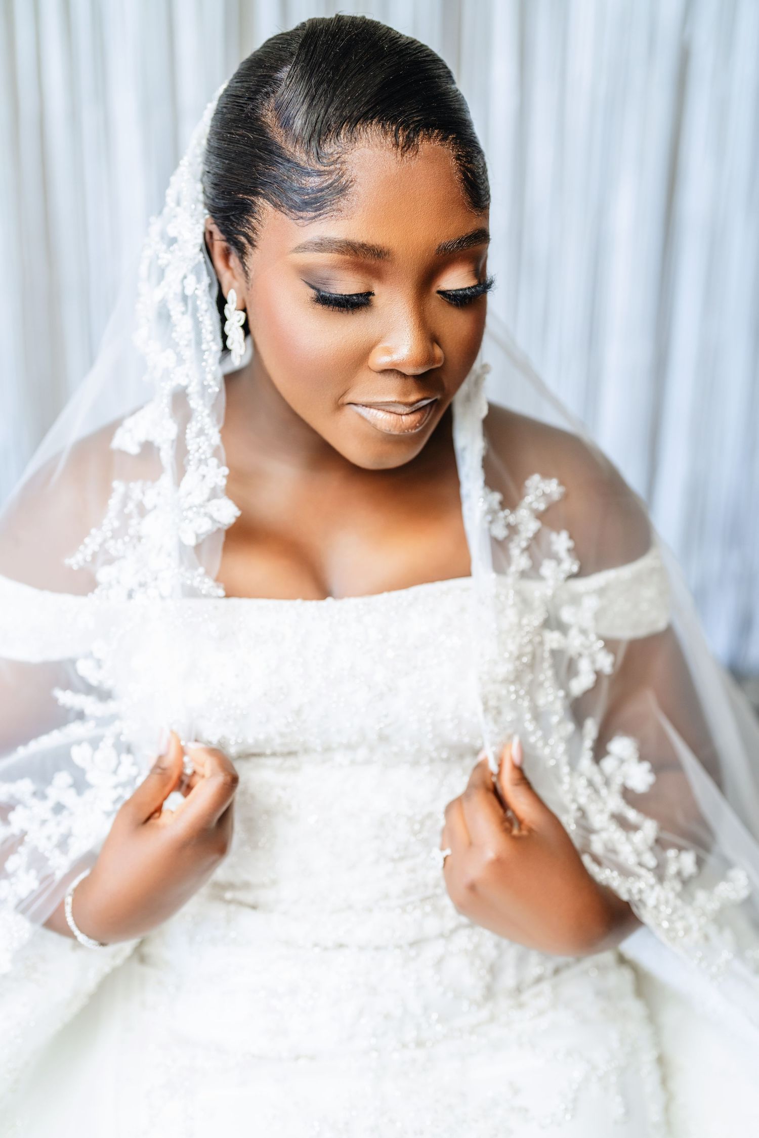 Close-up views of a stunning white lace wedding dress and veil with delicate details.