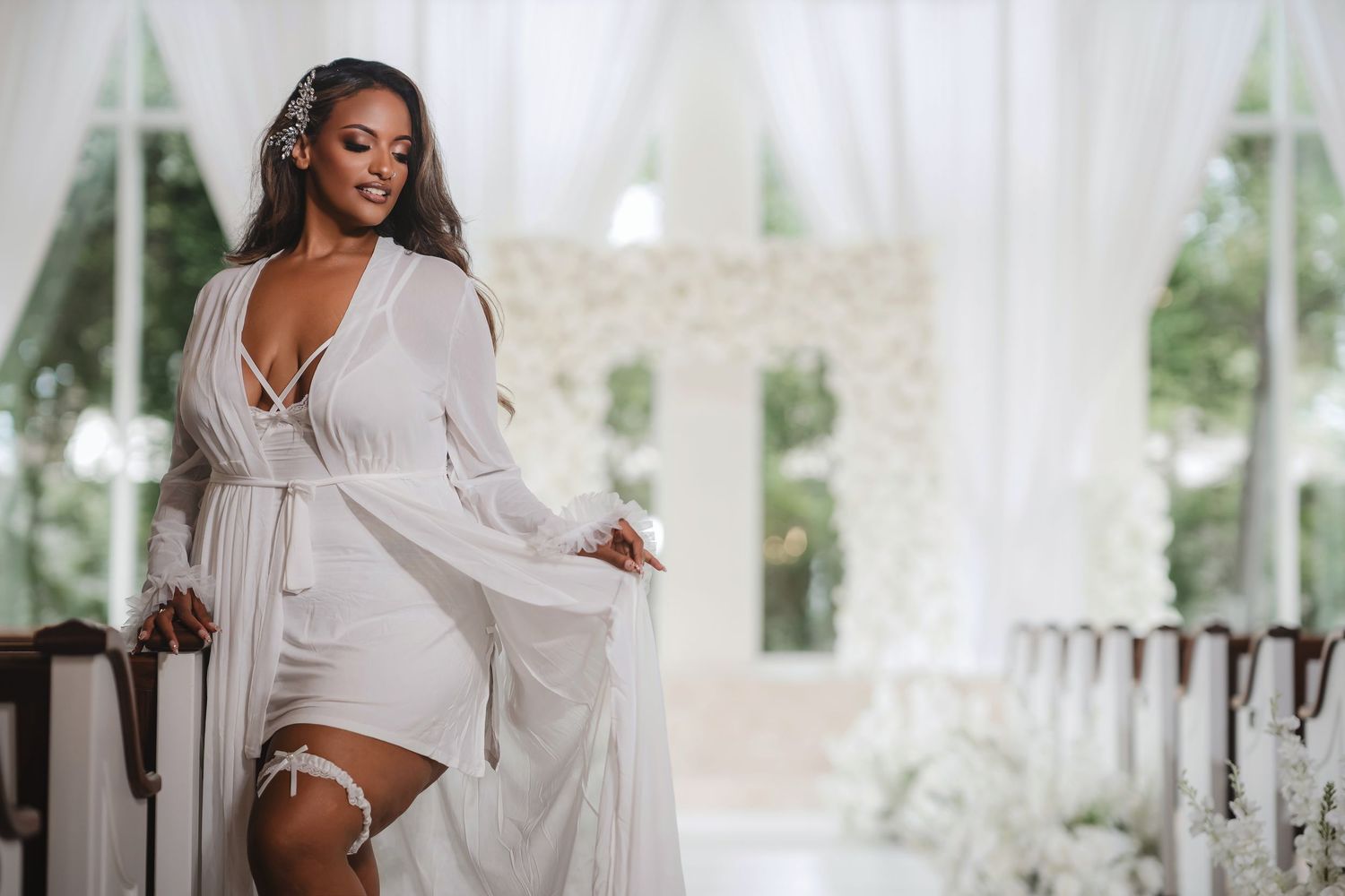 Bright wedding venue with white drapery and natural light streaming through windows.