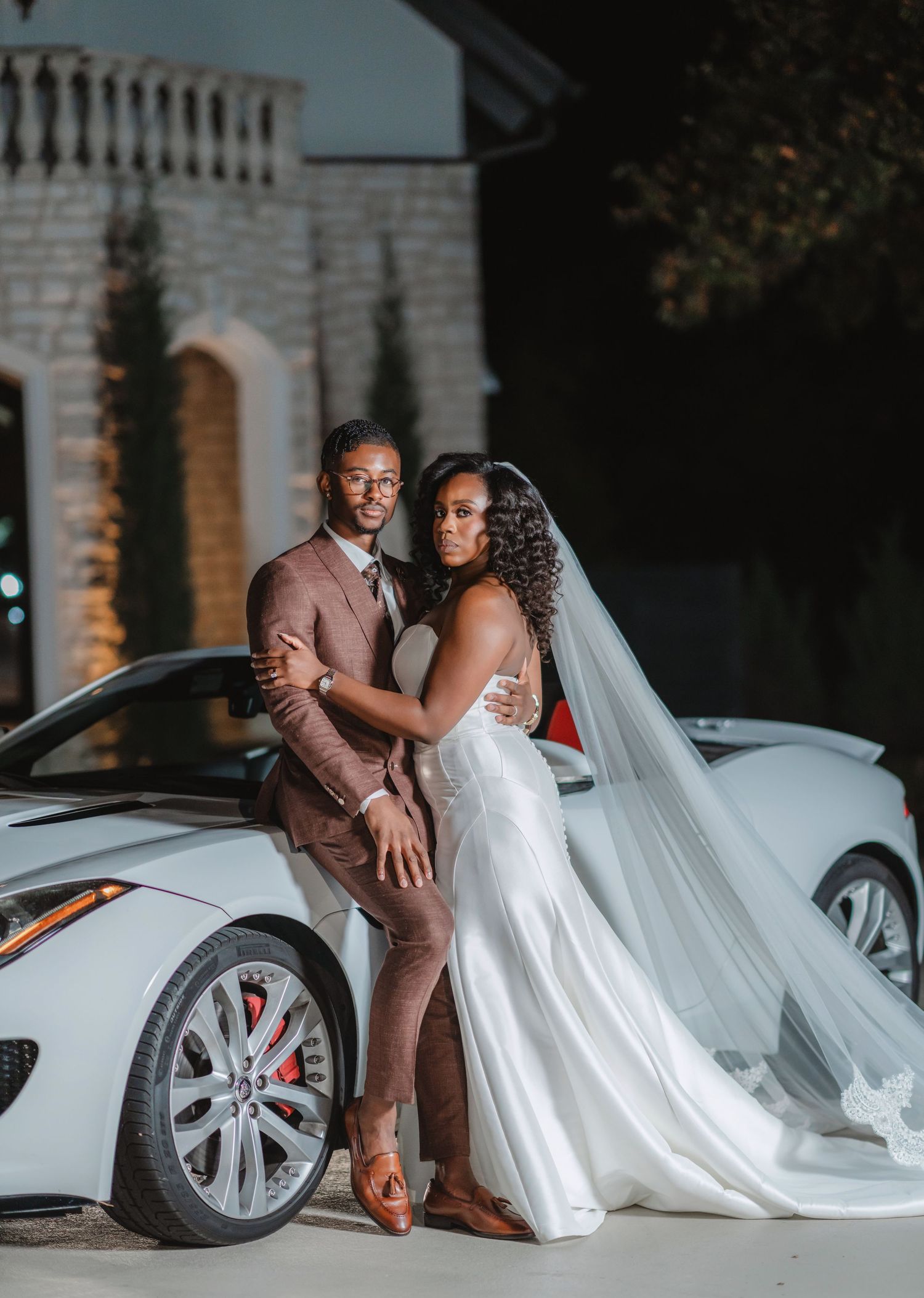 A romantic wedding photo series showing a couple posing beside a white luxury car at dusk.
