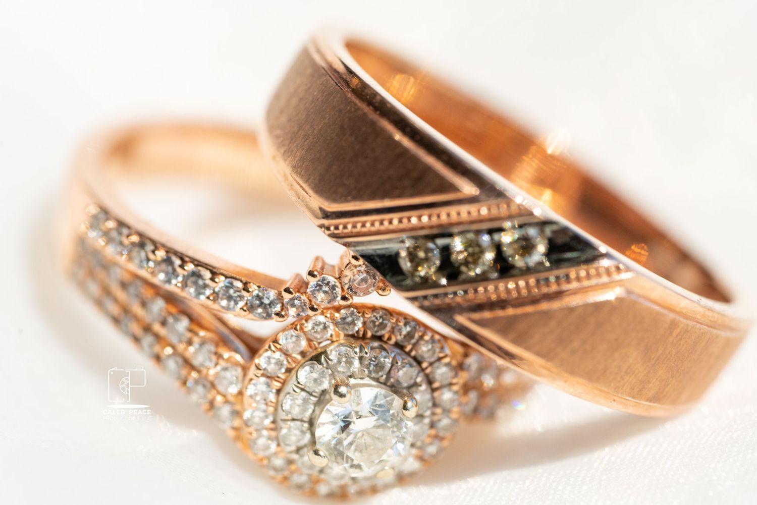 Close-up of rose gold wedding rings with intricate diamond details and vintage-inspired designs.