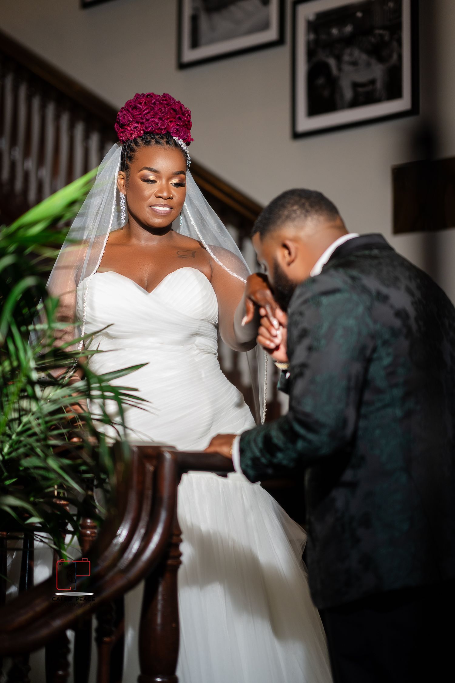 A romantic wedding moment captured on a staircase with pink floral crown and flowing white gown details.
