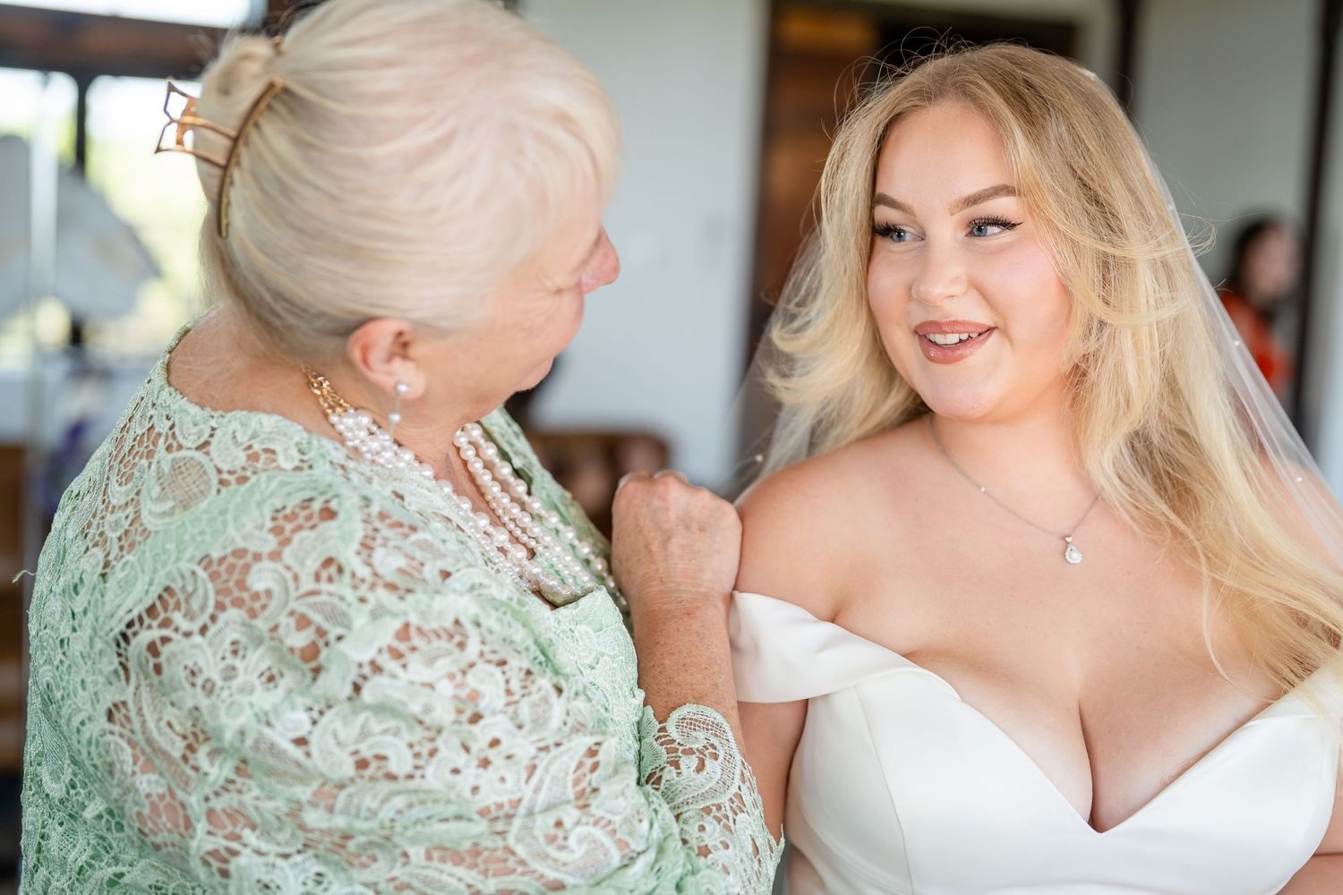Two people share an emotional moment in formal attire with mint green accents.