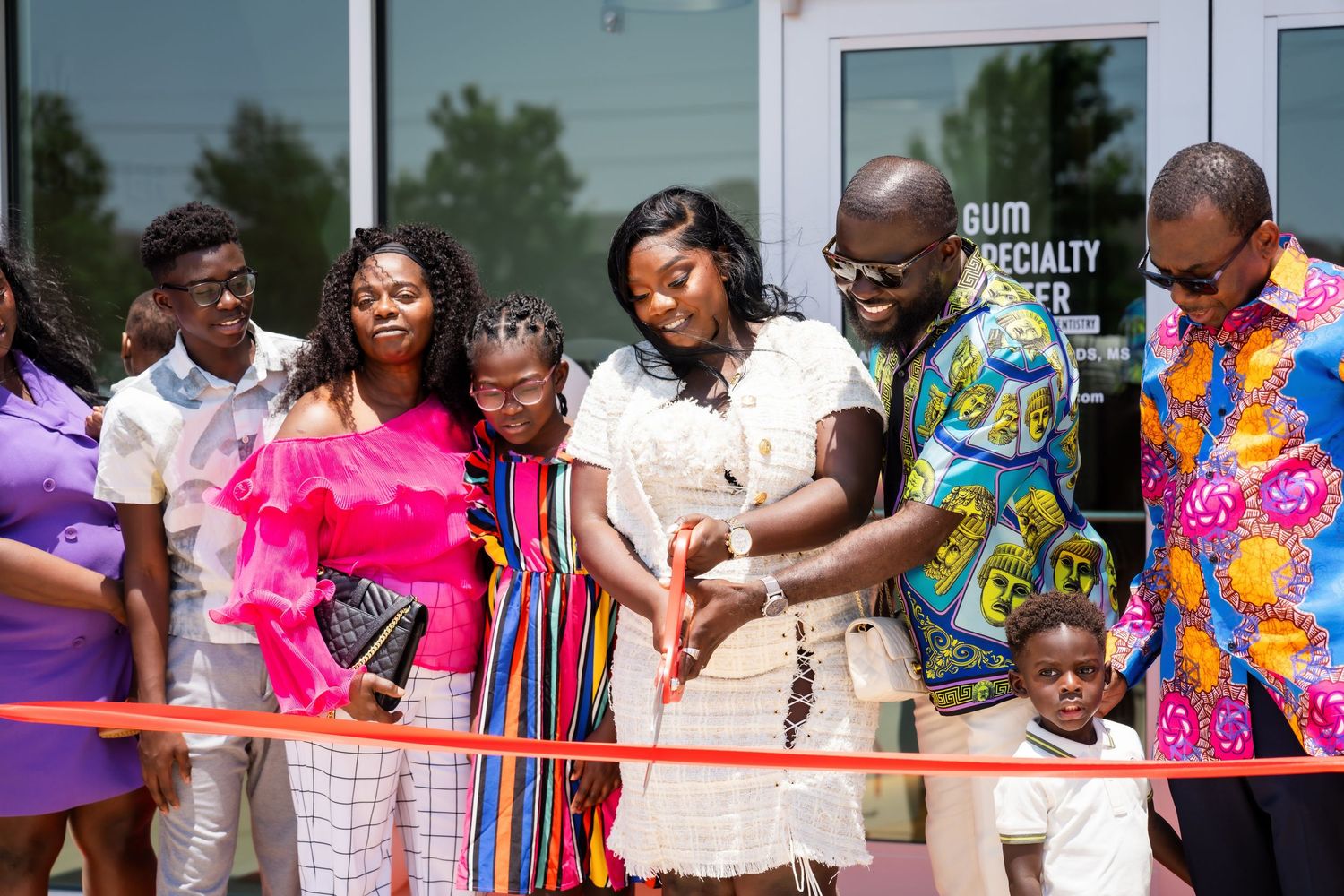 People in colorful traditional African attire celebrate during an outdoor community event.