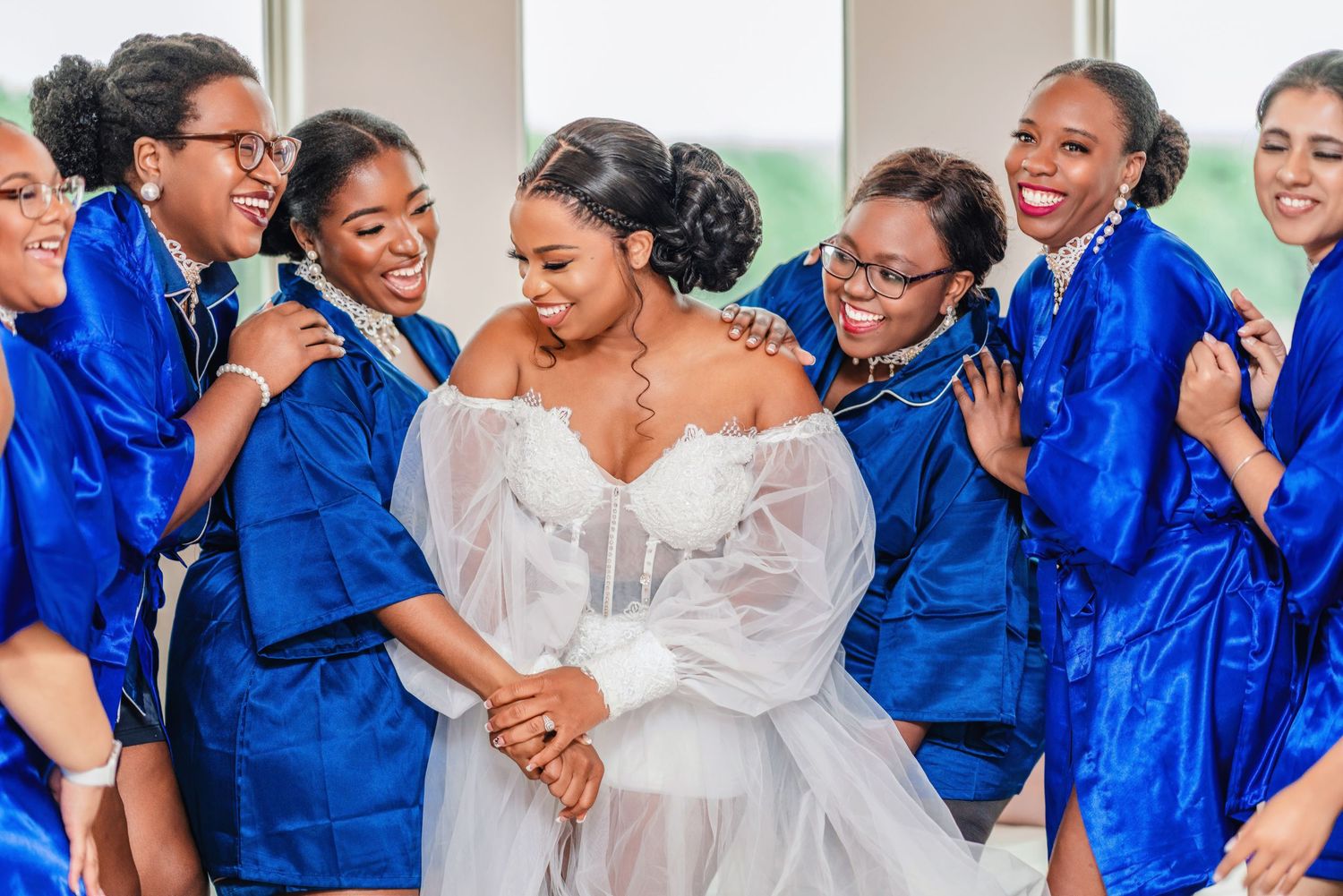 Wedding celebration with attendants in royal blue dresses sharing joyful moments together.