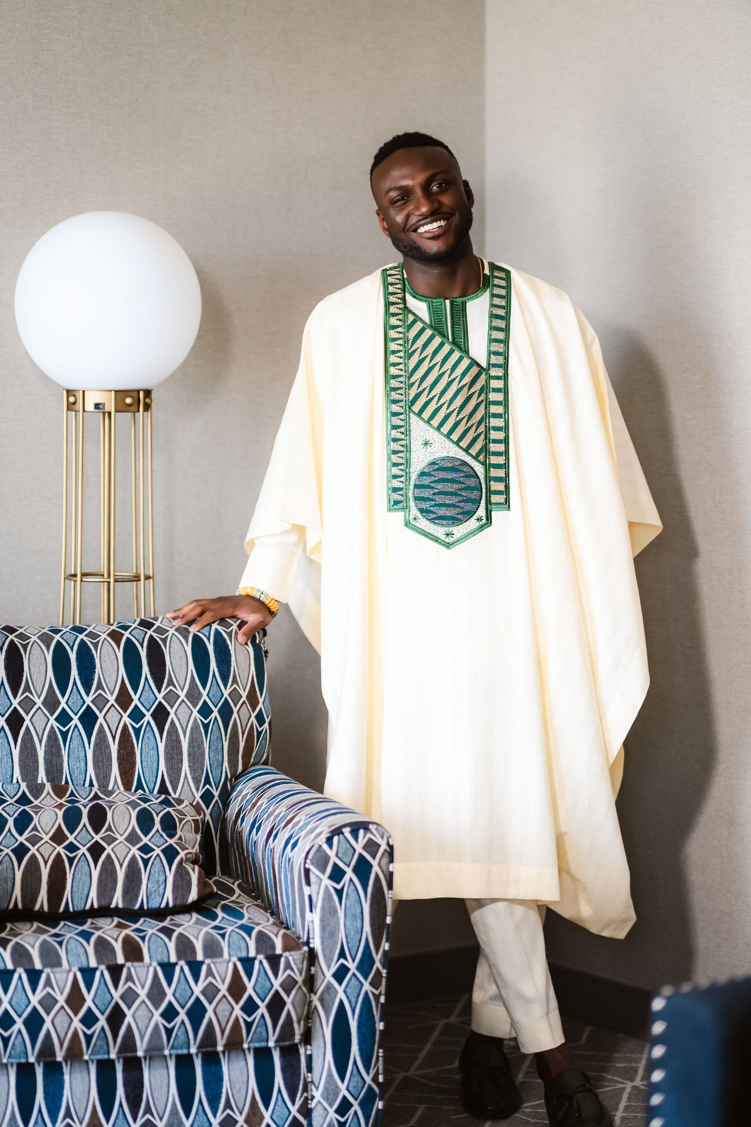 A series of photos showing a traditional cream-colored agbada with green embroidered neckline against a blue patterned chair.