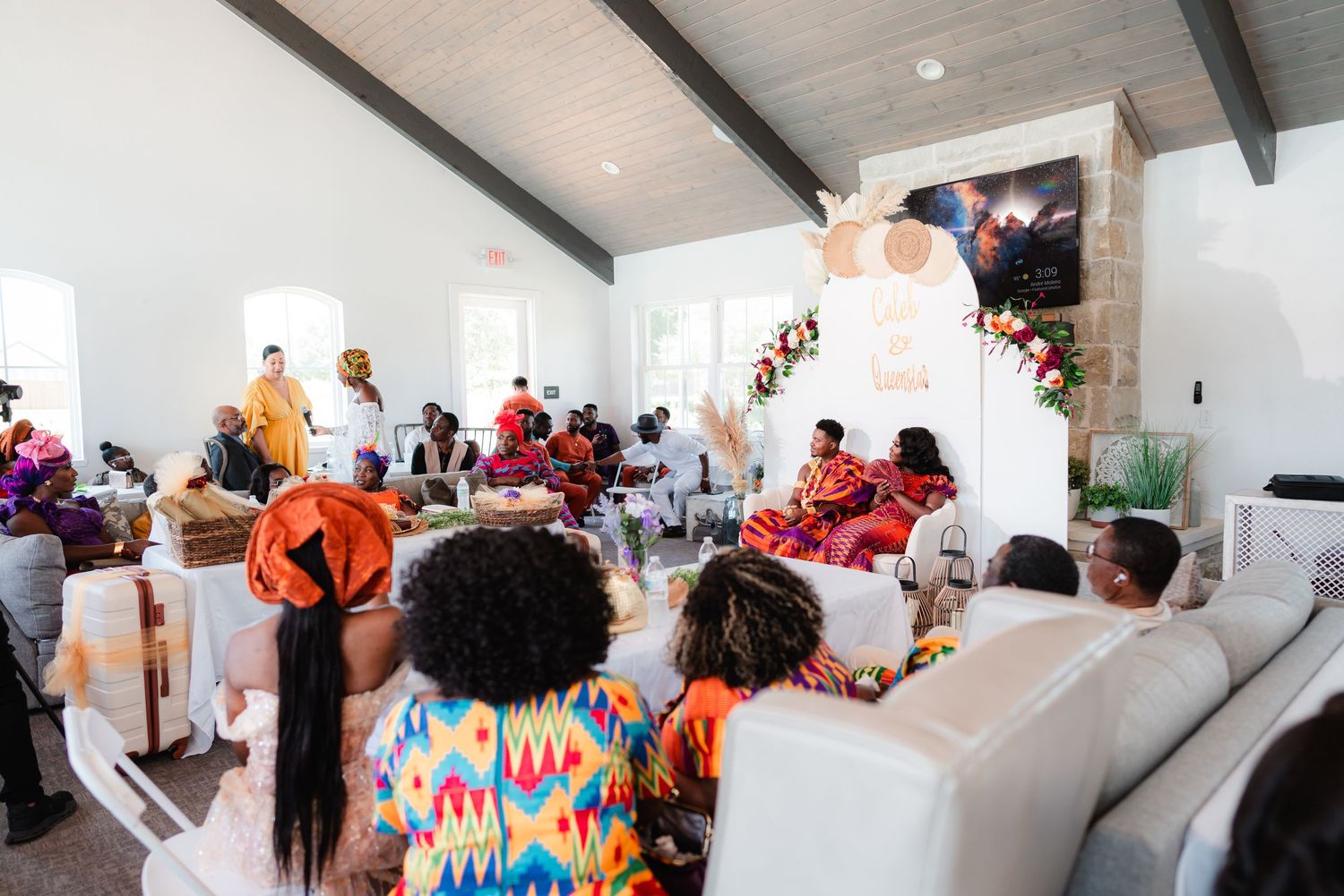 A festive indoor celebration with colorful decorations and guests seated in a bright modern venue.