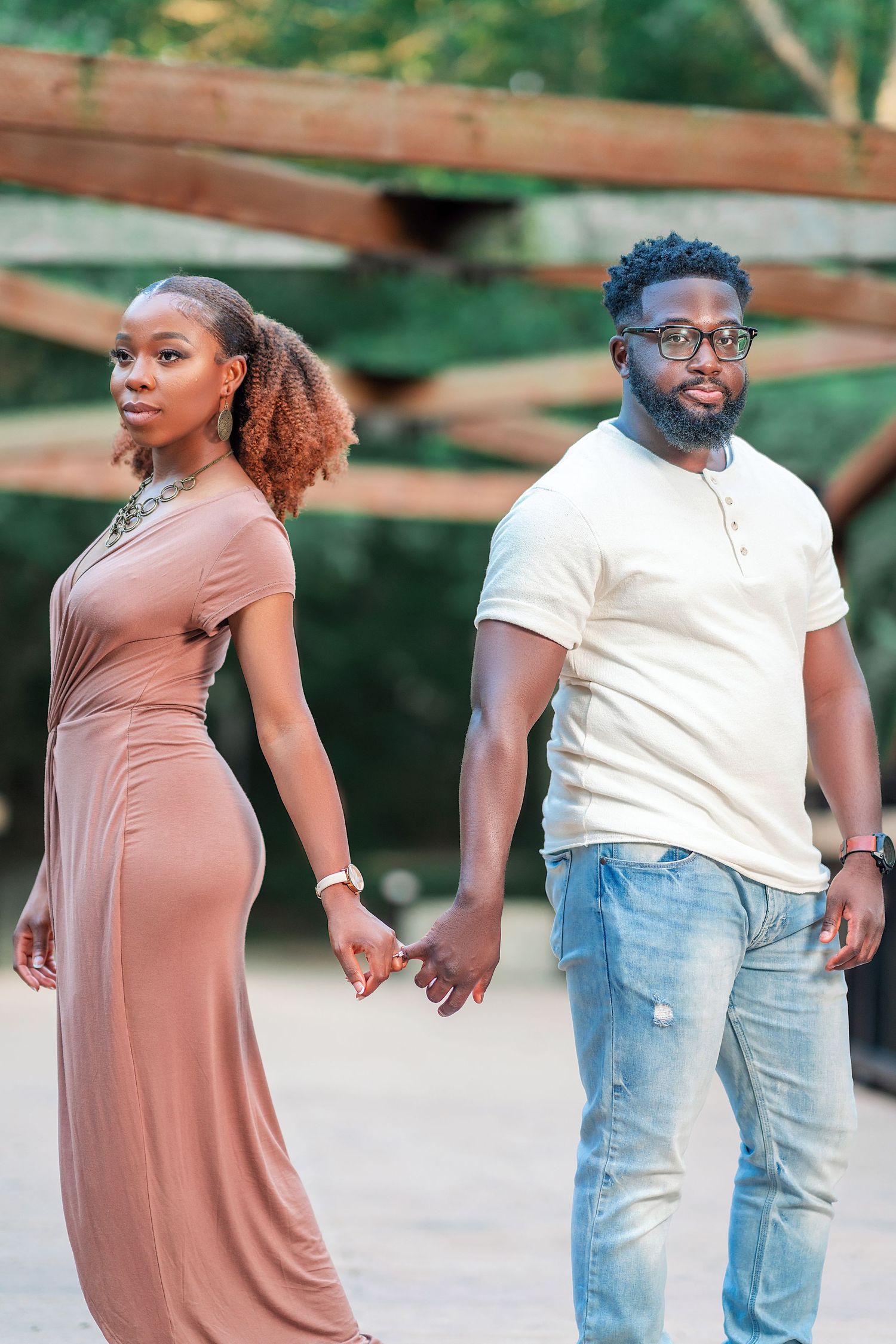 A couple poses together on a wooden deck during a summer photoshoot.