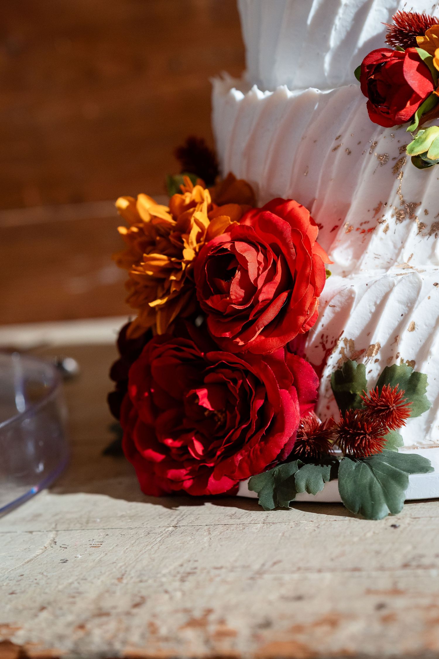 Deep red roses and floral decorations against a white textured surface.