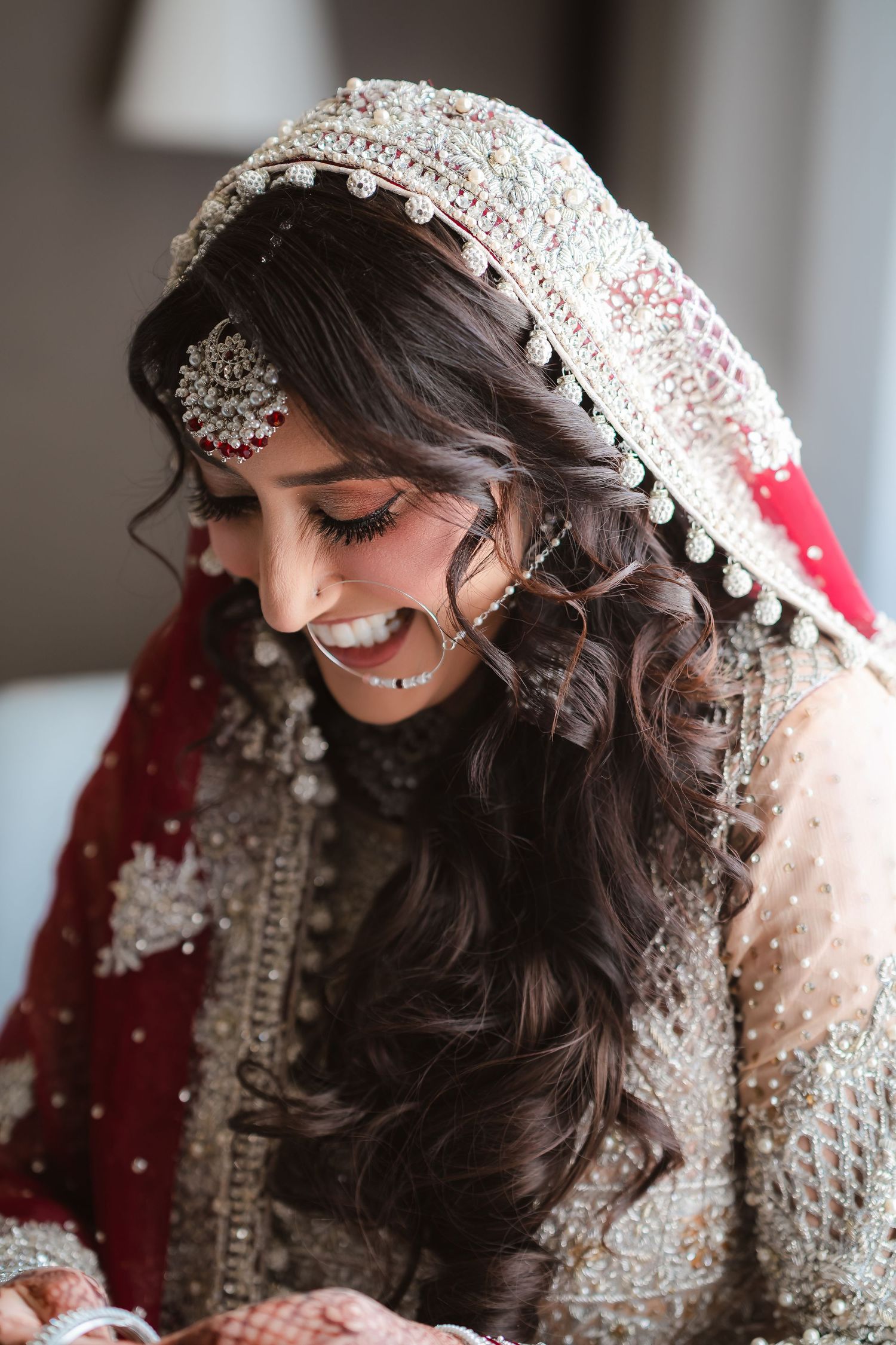 Traditional South Asian bride wearing an ornate silver and white beaded headpiece with delicate details.