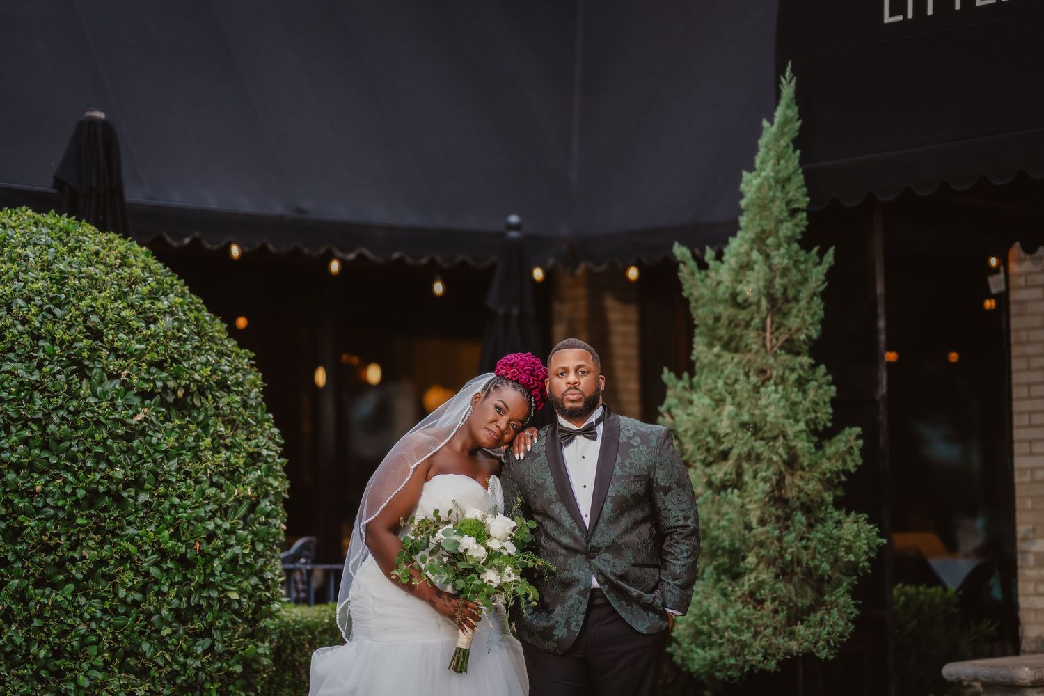 Nighttime wedding celebration with decorative lighting and greenery.