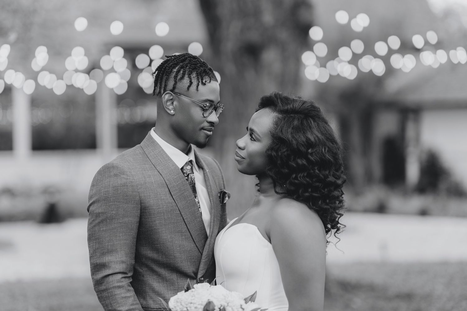 Black and white wedding portrait showing a tender moment between newlyweds.