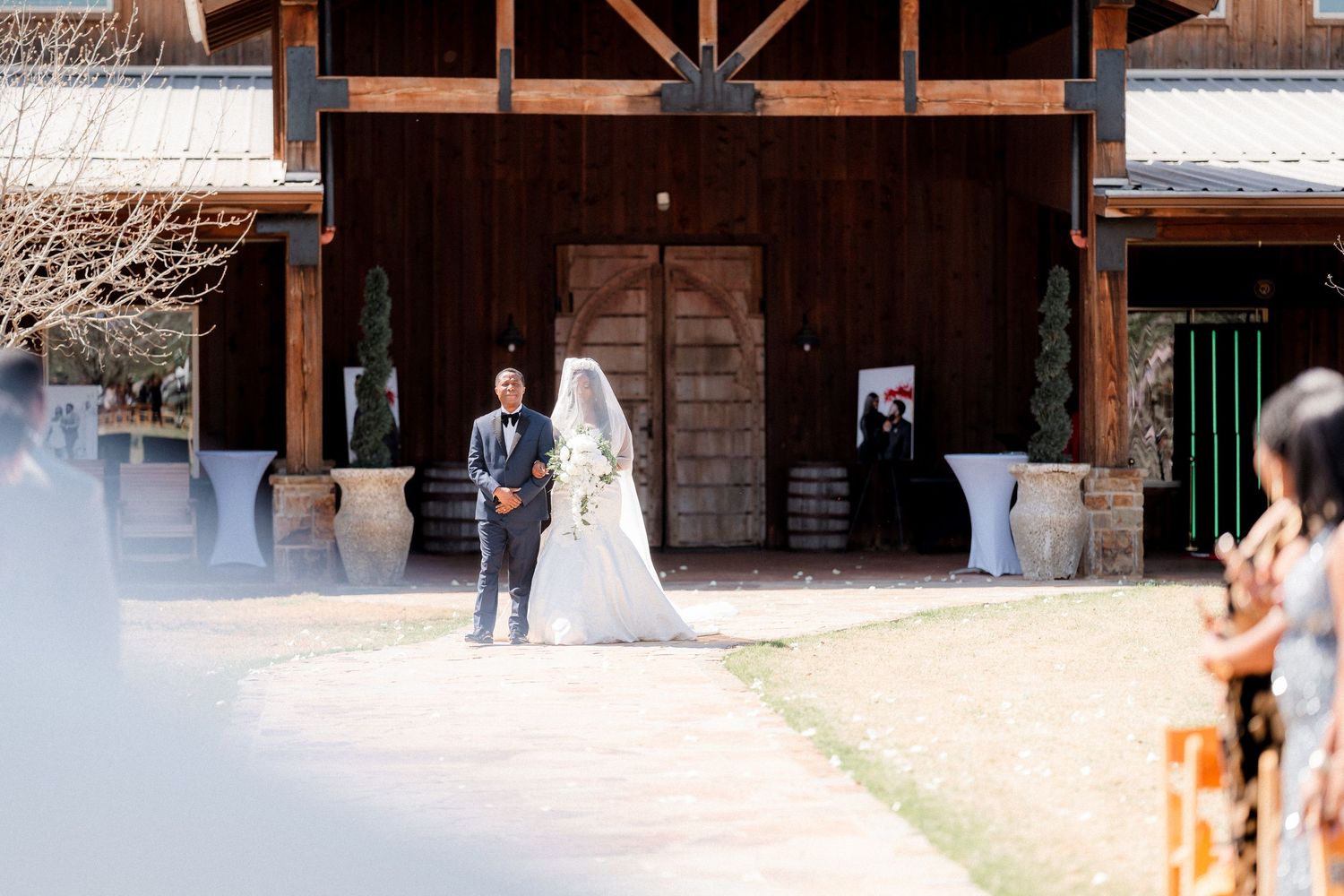 Rustic wooden barn interior with exposed beams and multiple doorways creating a warm, natural atmosphere.