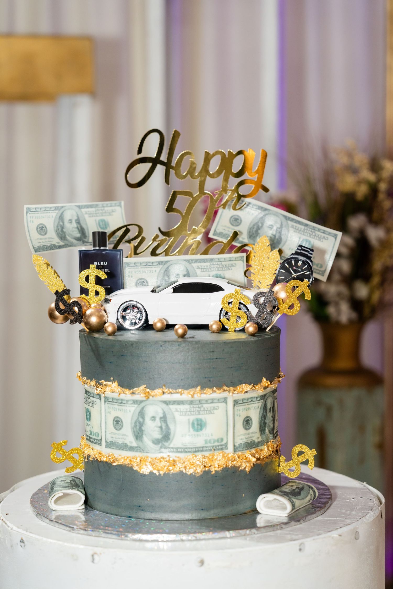 Money themed birthday cake decorated with dollar bills and gold accents on a white cake stand.