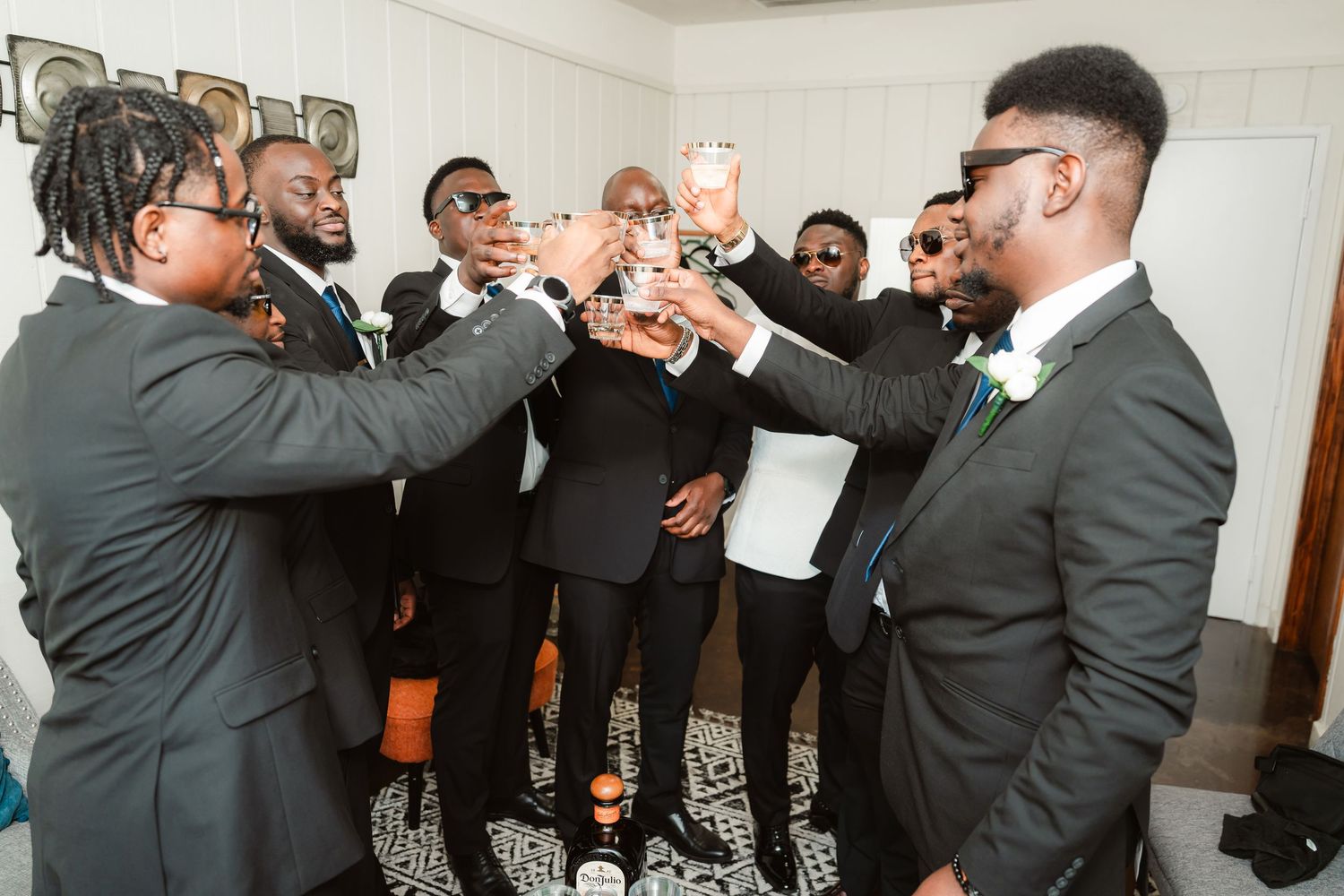 Large group of wedding guests dancing and celebrating together at a reception venue.