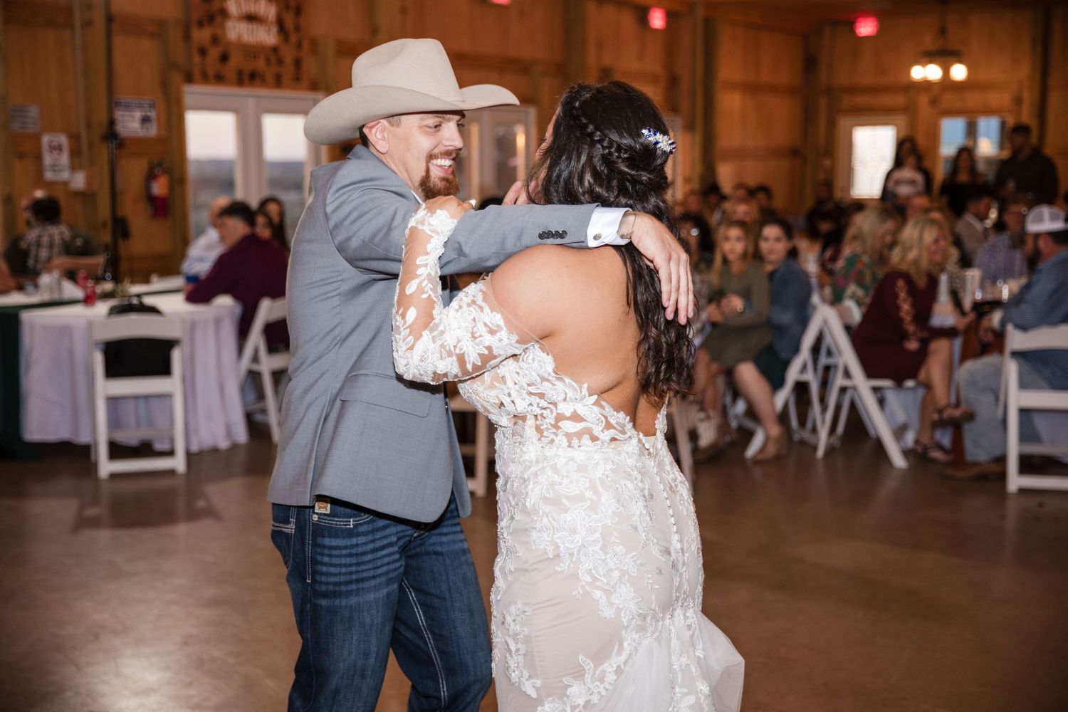 Wedding celebration inside rustic barn venue with warm lighting.