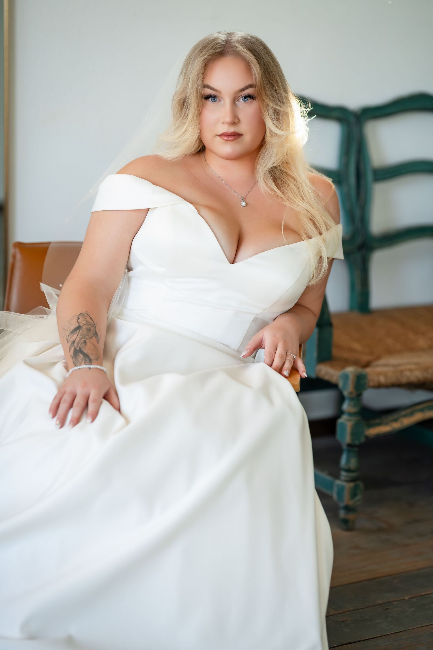 Elegant bridal portrait featuring a white wedding dress against a rustic indoor setting.