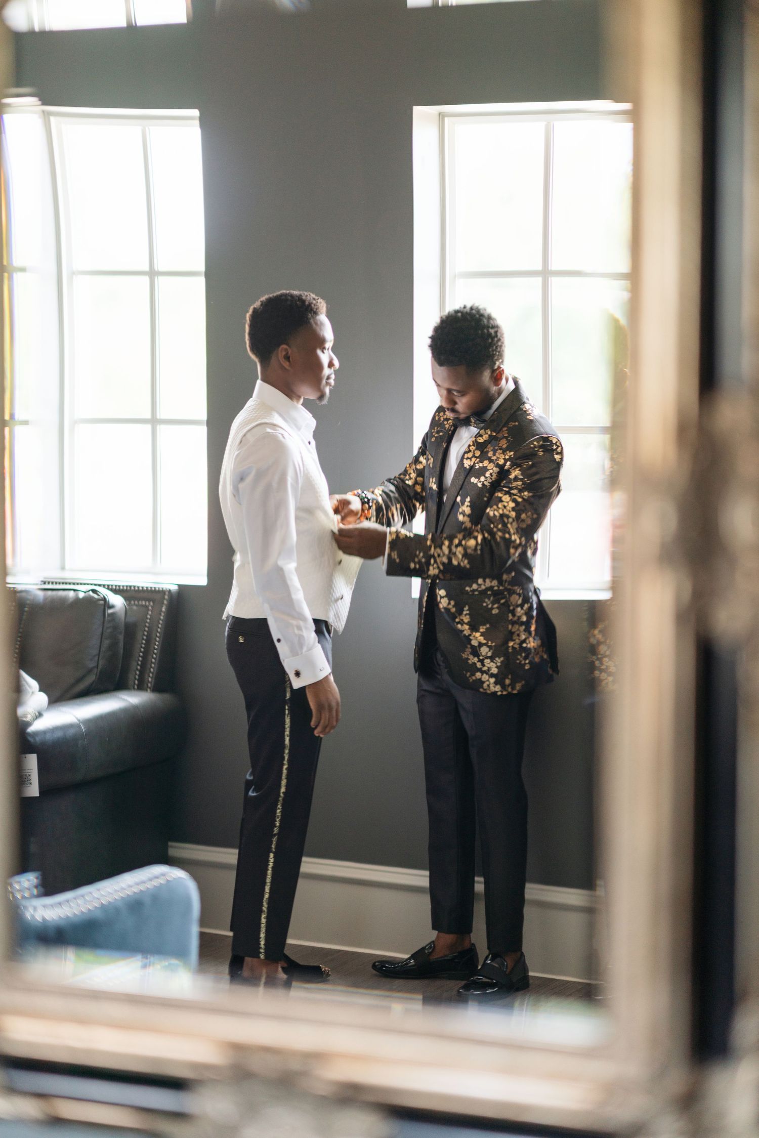 Wedding preparation scene reflected in mirrors showing formal attire and special moments.