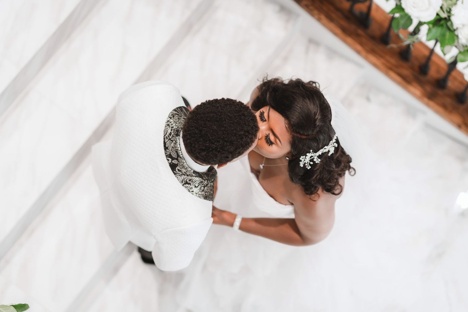 Intimate wedding portrait showing couple in close embrace against rustic wooden backdrop.